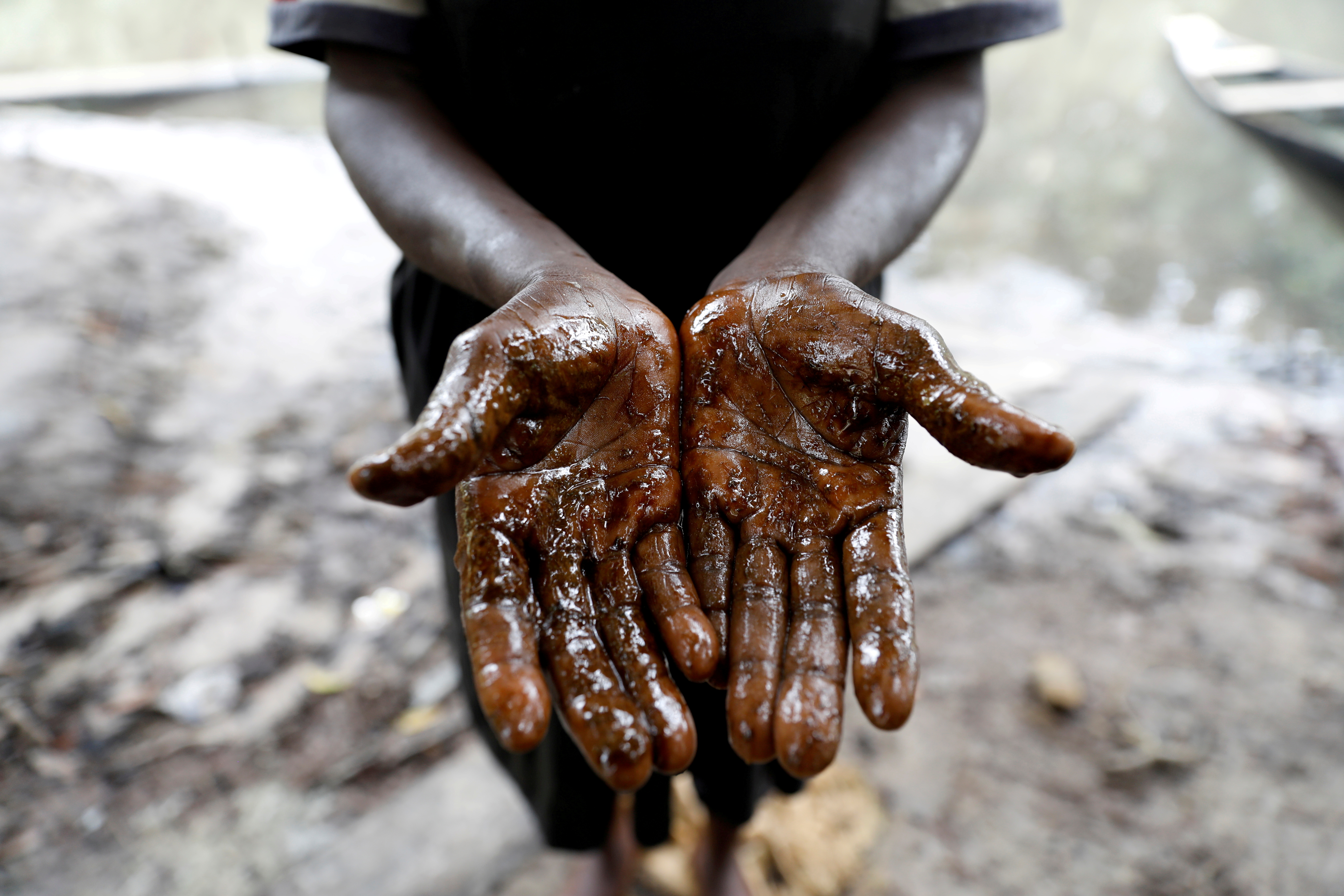 Afieyegha Seiyefa, a fisherwoman shows her hands stained by oil, following an oil spill at Santa Barbara in Nembe Bayelsa