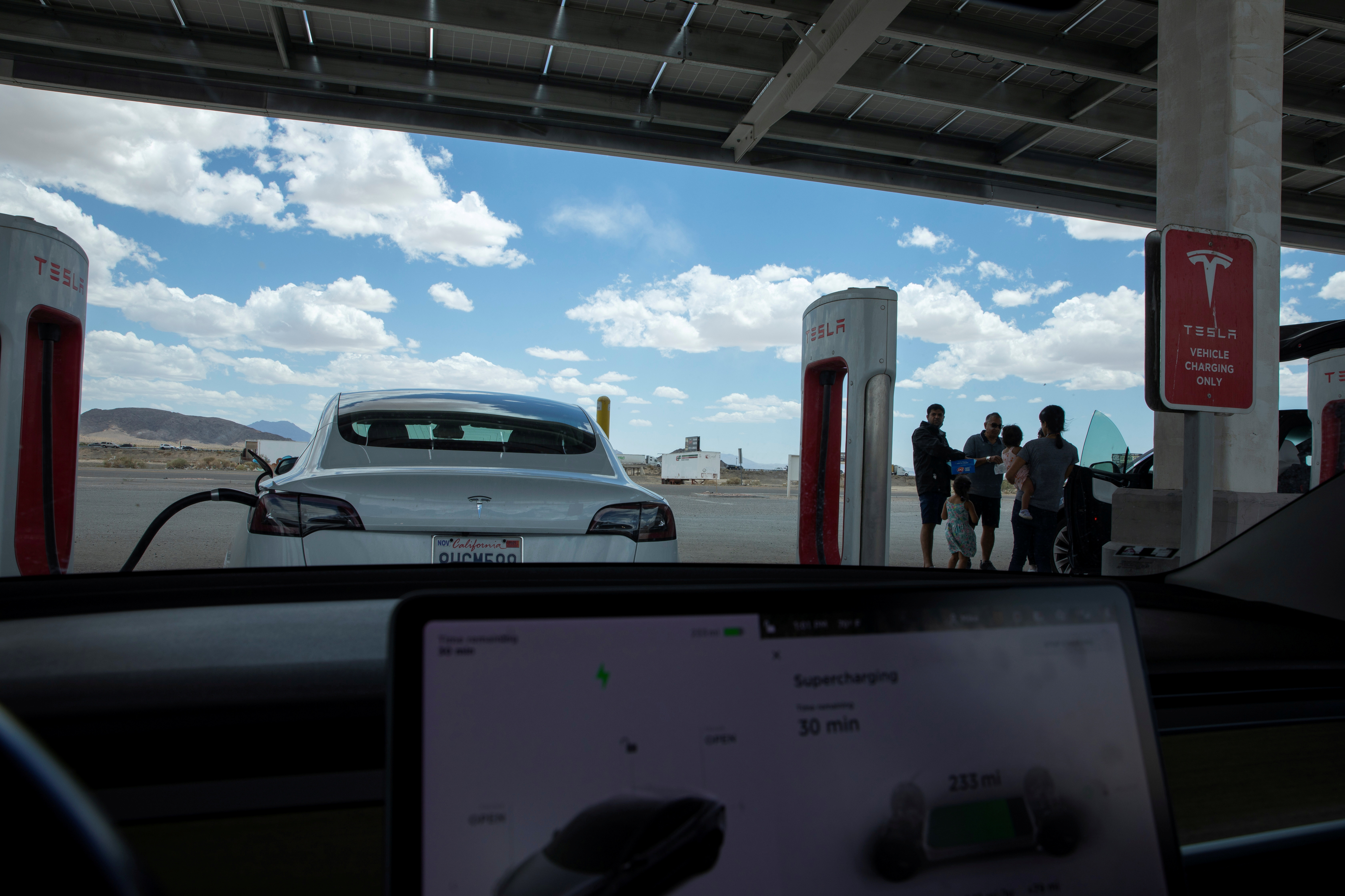 Tesla electric vehicles recharge at a large supercharging station located between Los Angeles and Las Vegas
