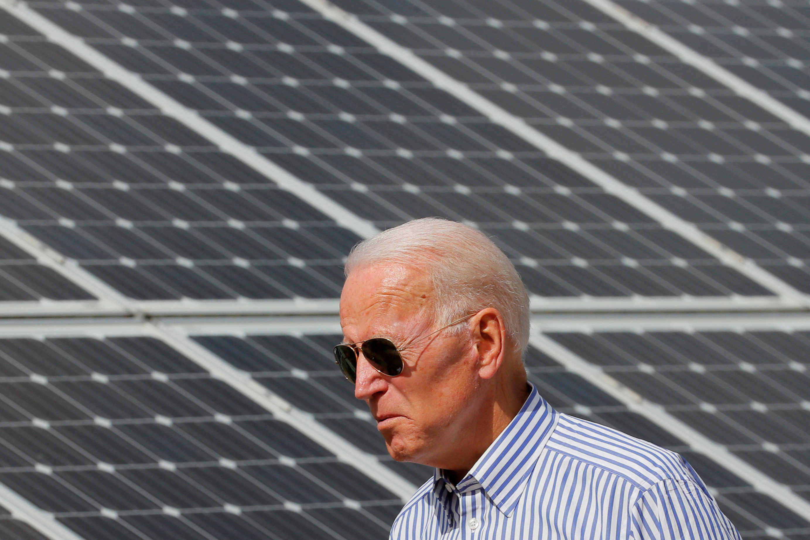 Democratic 2020 U.S. presidential candidate Biden walks past solar panels in Plymouth