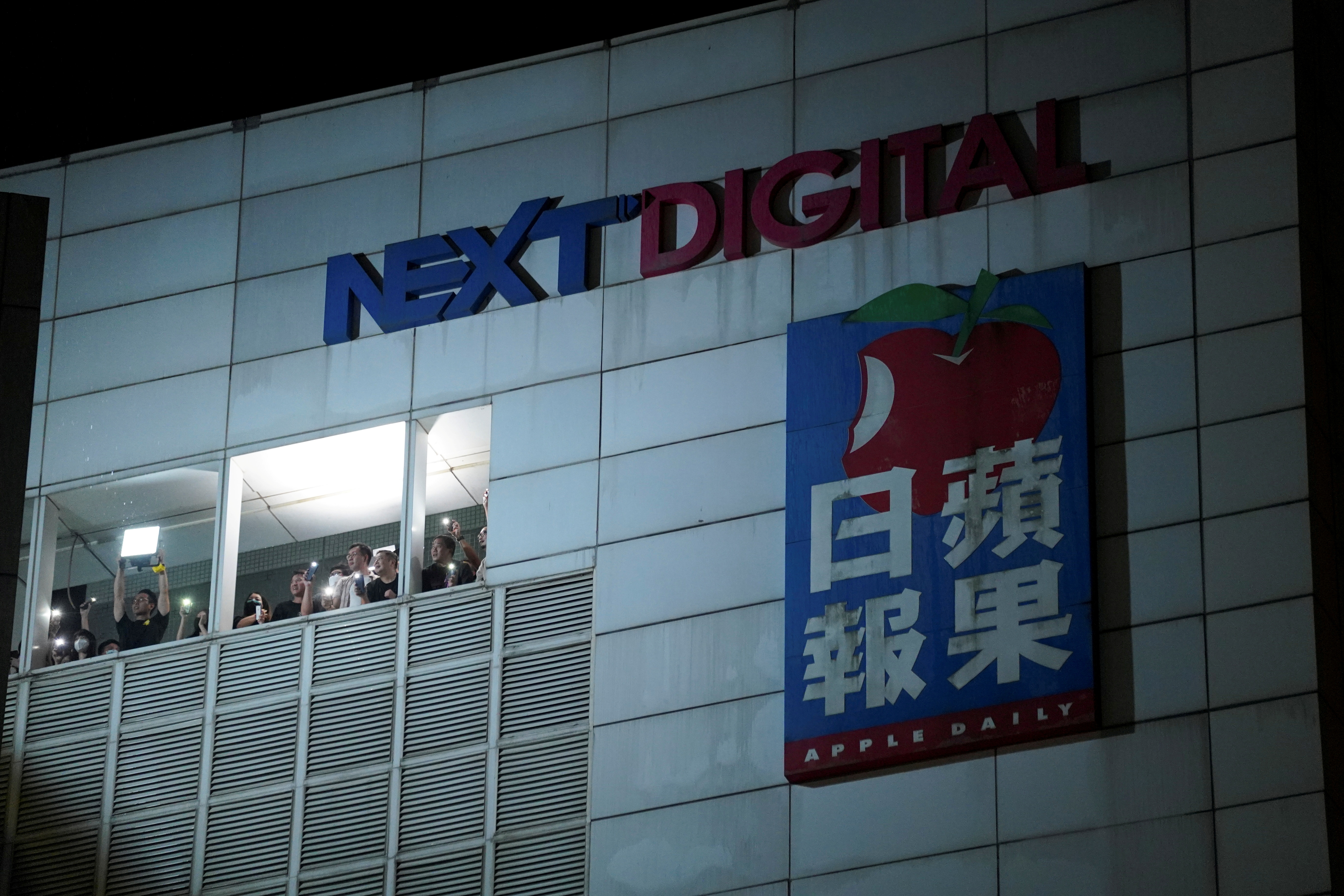 Staff light their phone flashlights at the offices of Apple Daily and its publisher Next Digital, after the announcement it will print its last edition, in Hong Kong, China June 23, 2021. REUTERS/Lam Yik