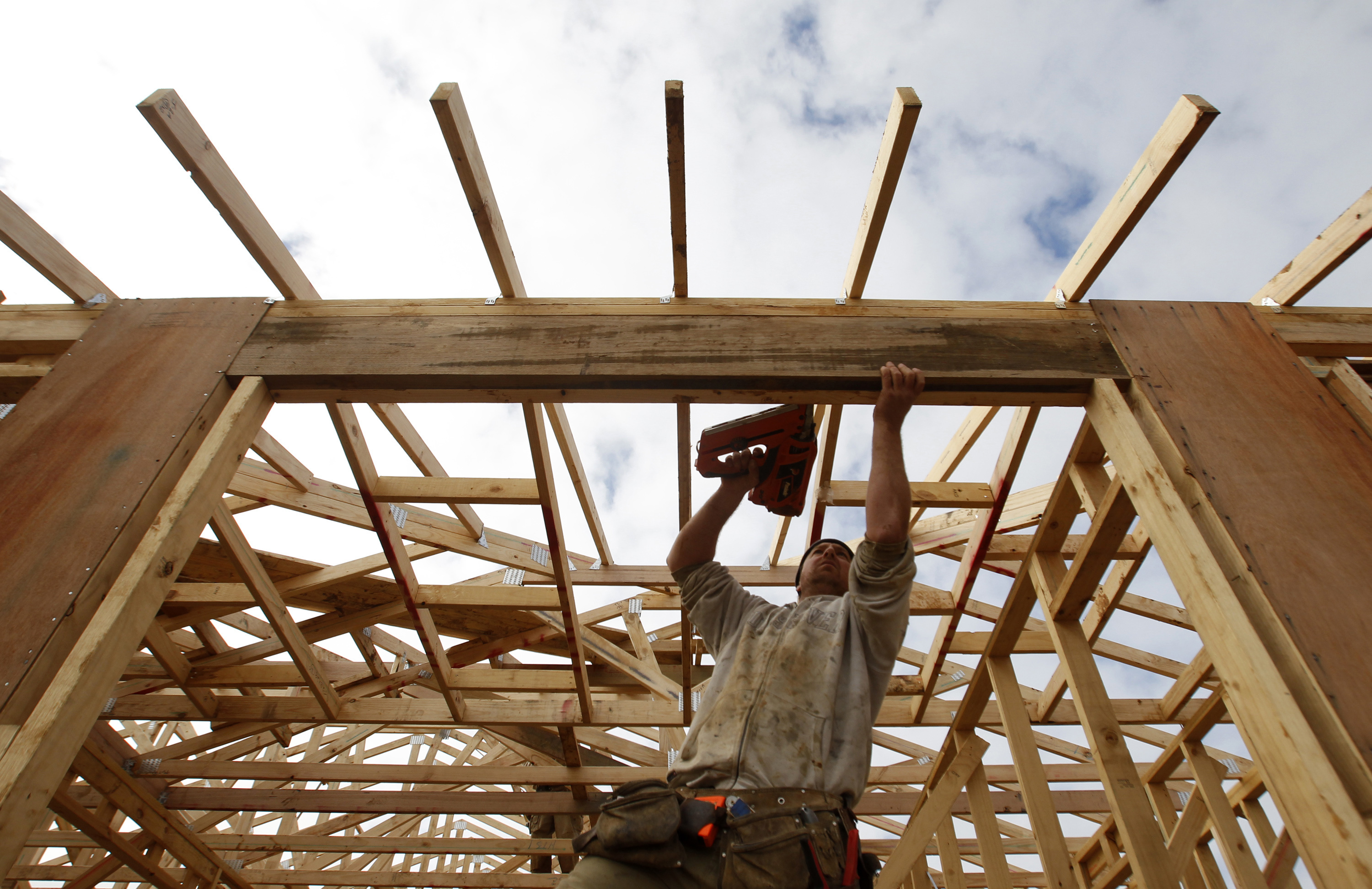 A tradesman works on the framework of a new house on the outskirts of Melbourne