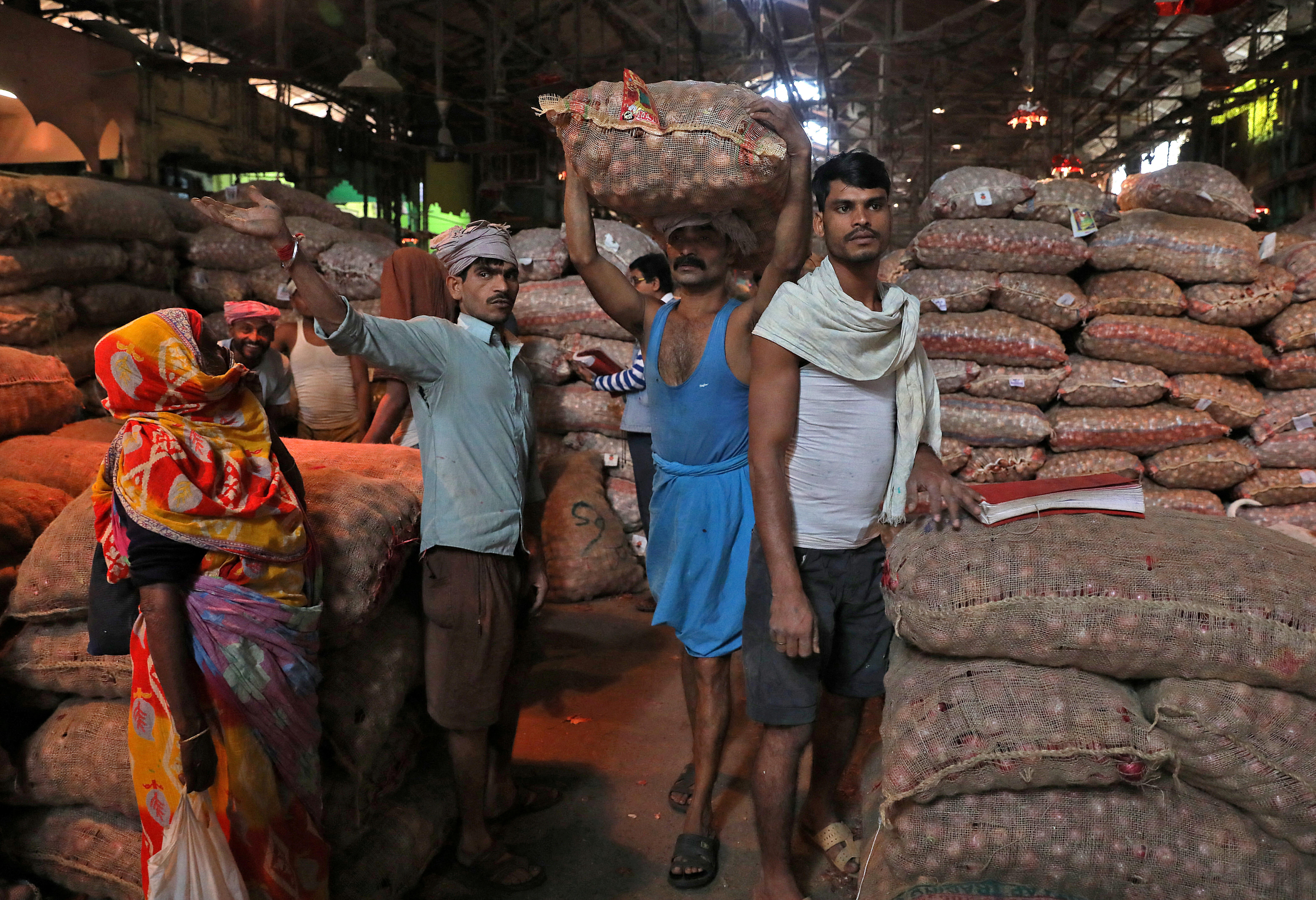 Labourer carries sack of onions at wholesale market in Kolkata
