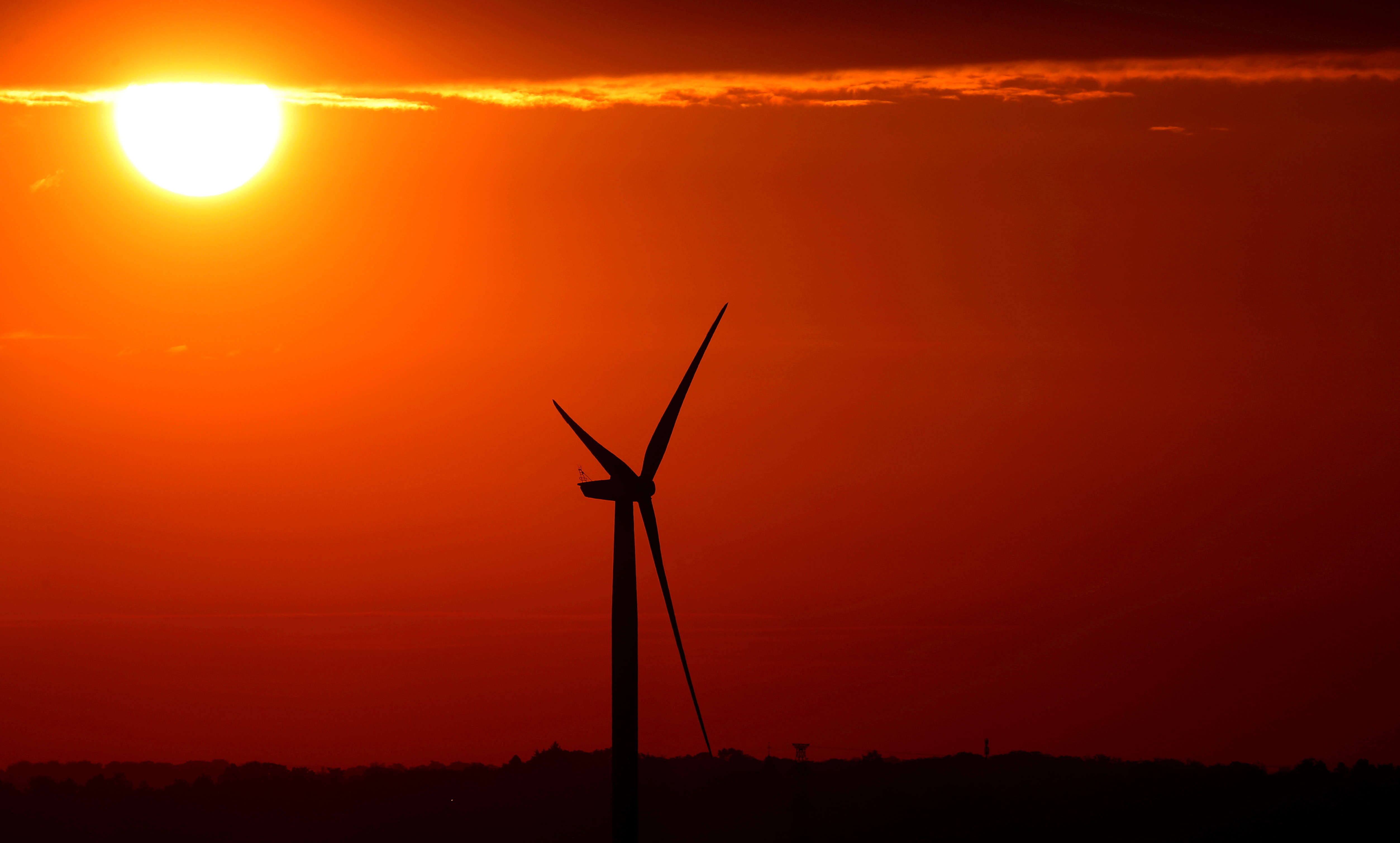 The sun rises behind an electric power windmill in Halle, Belgium September 11, 2019.