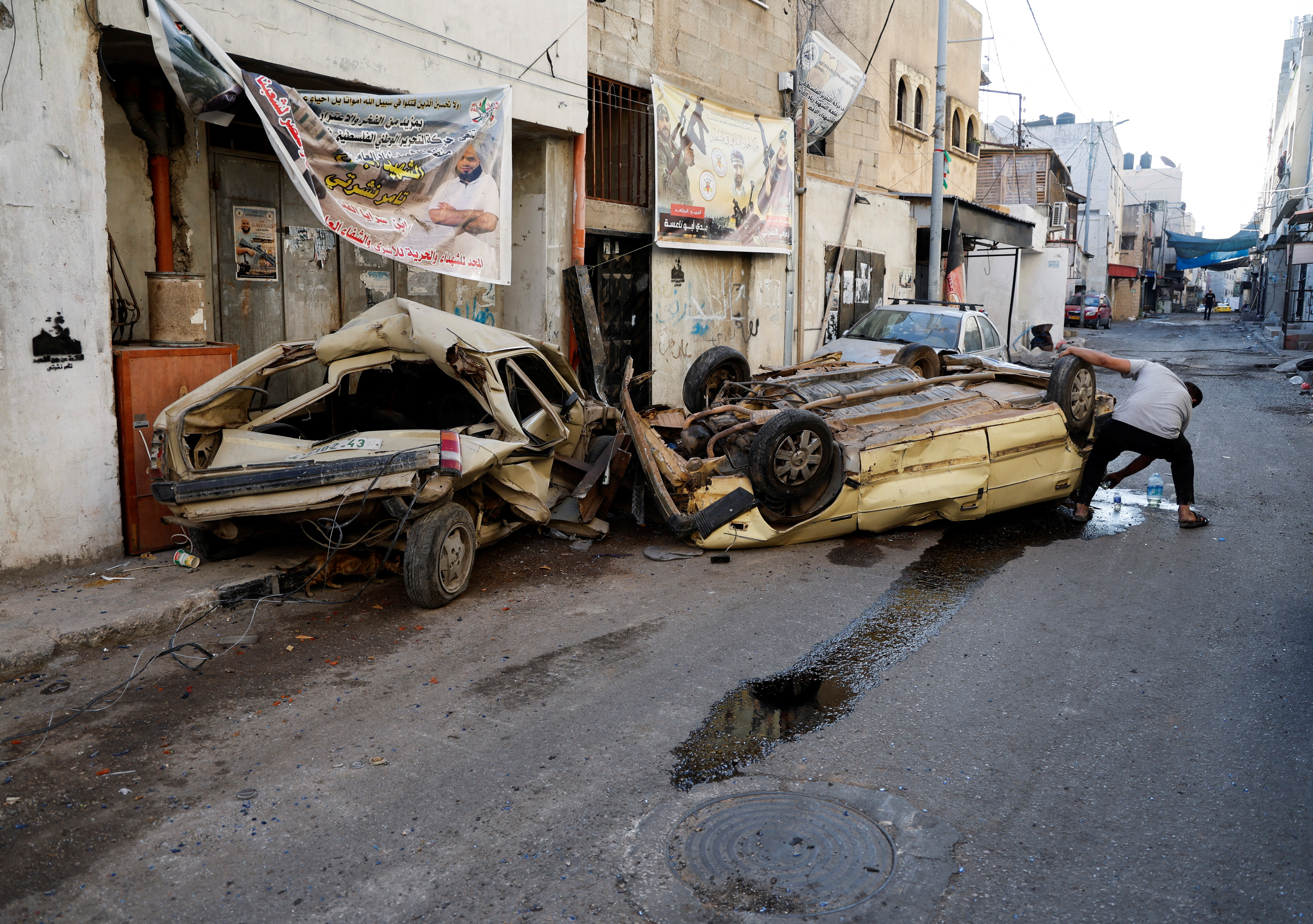 A man stands next to a damaged car after the Israeli army's withdrawal from the Jenin camp