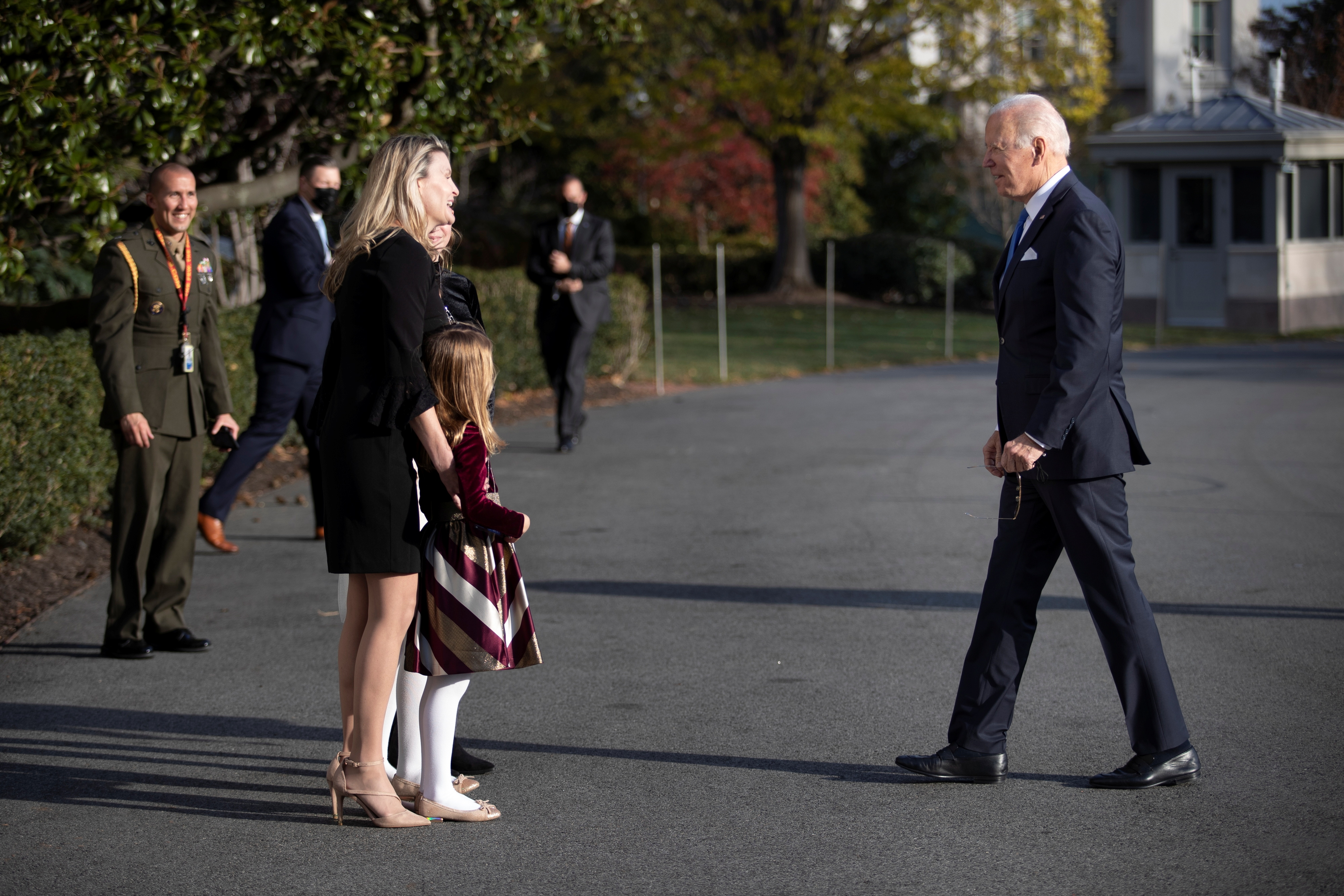 U.S. President Joe Biden greets the family of a HMX-1 Marine One pilot who was conducting his last flight in service, while walking to the Oval Office, at the South Lawn at the White House in Washington, U.S., December 2, 2021. REUTERS/Tom Brenner