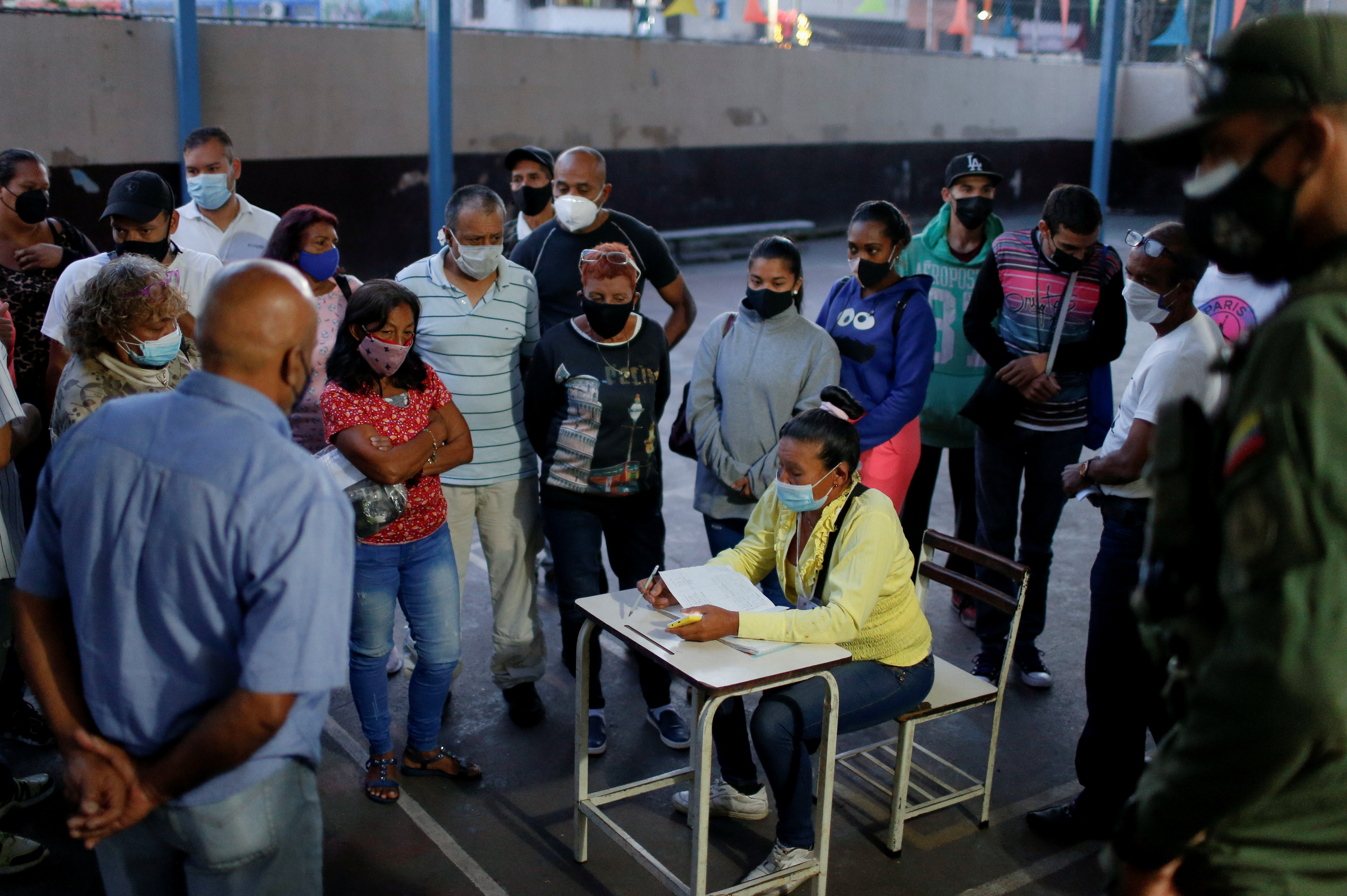 People wait for the opening of a table to vote in the election for state governors and local mayors, in Caracas, Venezuela November 21, 2021. REUTERS/Leonardo Fernandez Viloria