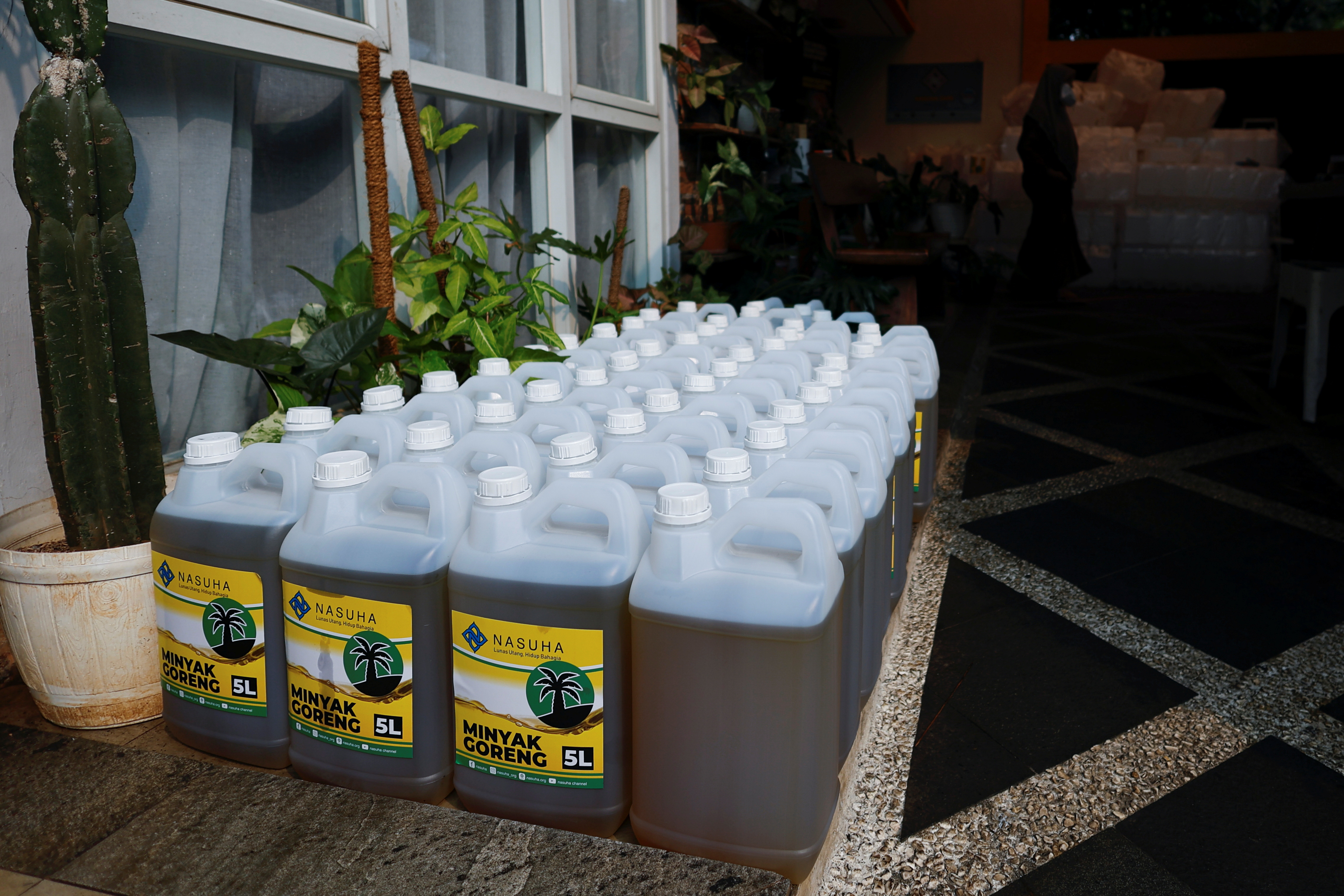 Containers with cooking oil to be distributed to residents are seen at a local filling station after stocks ran out in Jakarta
