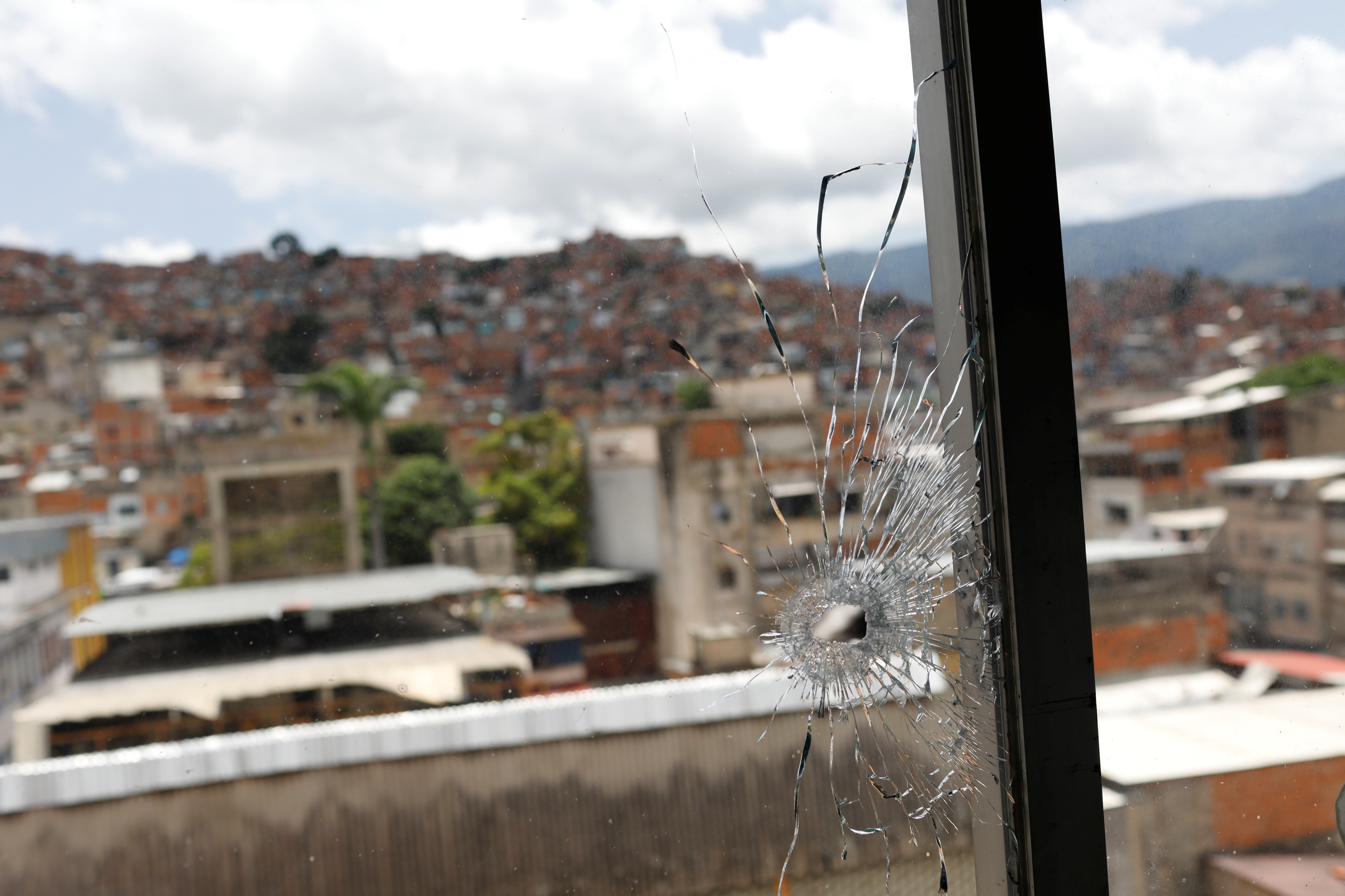 A window hit by a bullet is seen in the offices of the San Miguel Archangel church after armed confrontations between members of El Koki’s criminal gang and police forces in the El Cementerio neighborhood, in Caracas