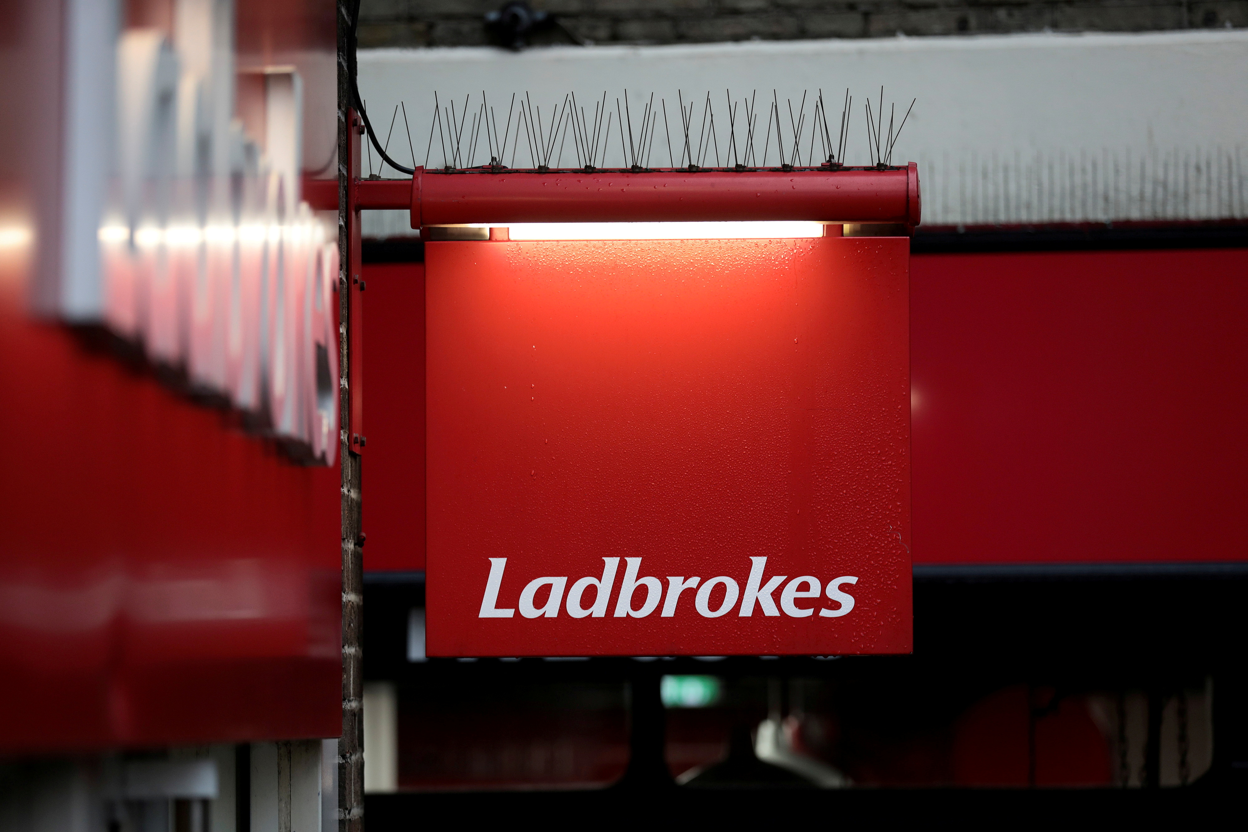 A sign hangs outside a branch of Ladbrokes in London