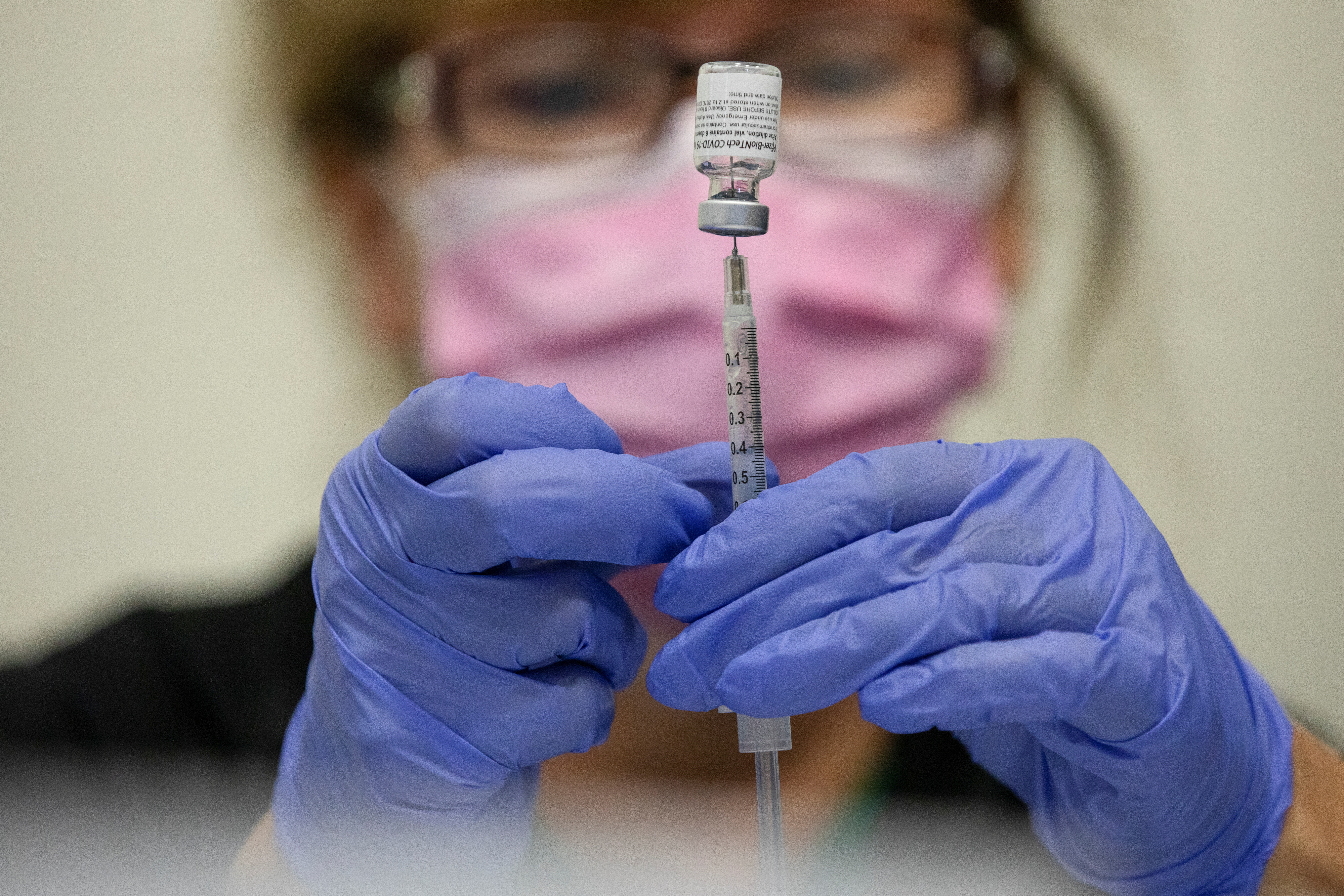 A nurses fills up syringes for patients as they receive their coronavirus disease (COVID-19) booster vaccination during a Pfizer-BioNTech vaccination clinic in Southfield, Michigan, U.S., September 29, 2021. REUTERS/Emily Elconin
