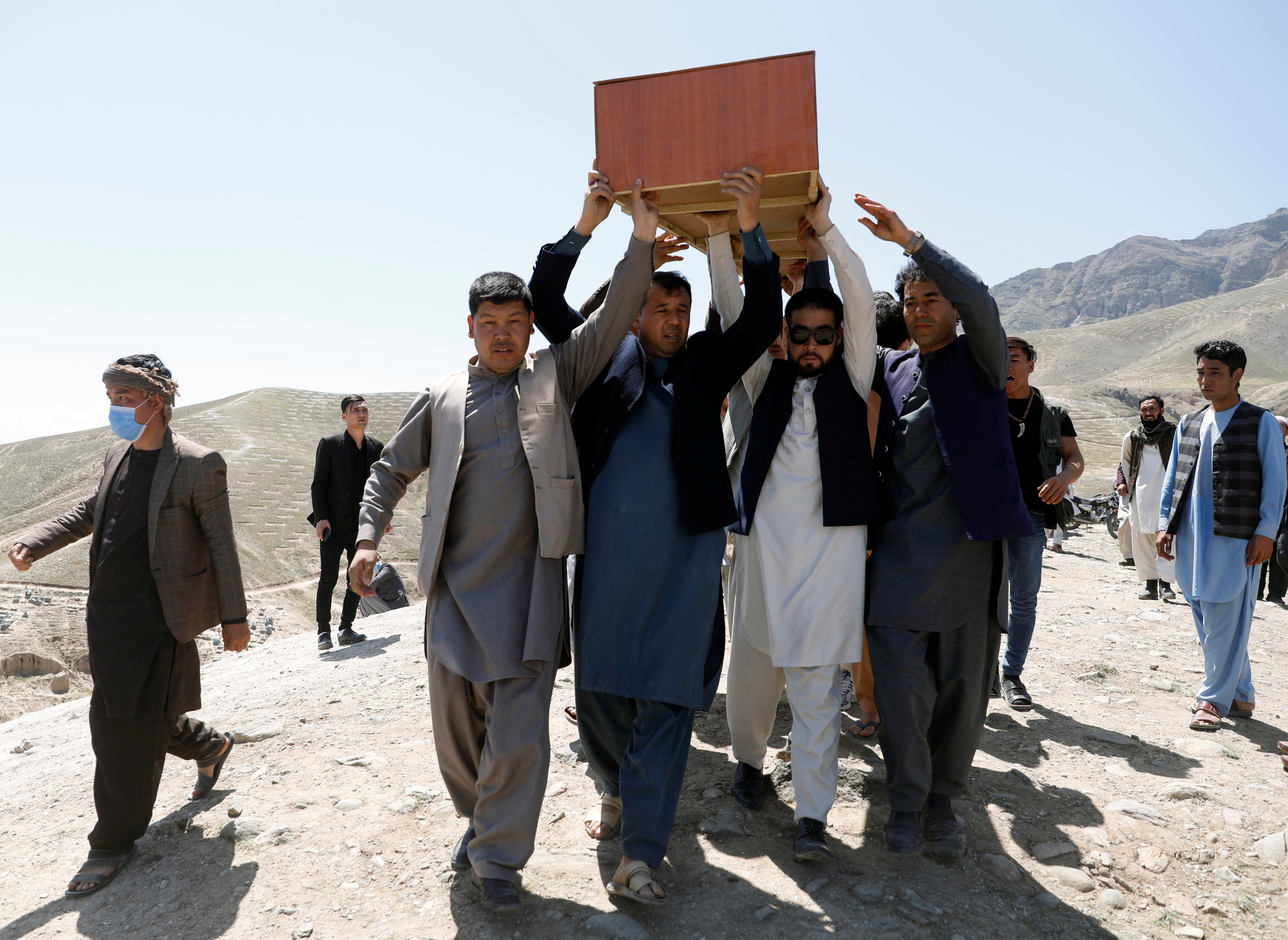 Afghan men carry the coffin of one of the victims of yesterday's explosion in Kabul, Afghanistan May 9, 2021. REUTERS/Stringer