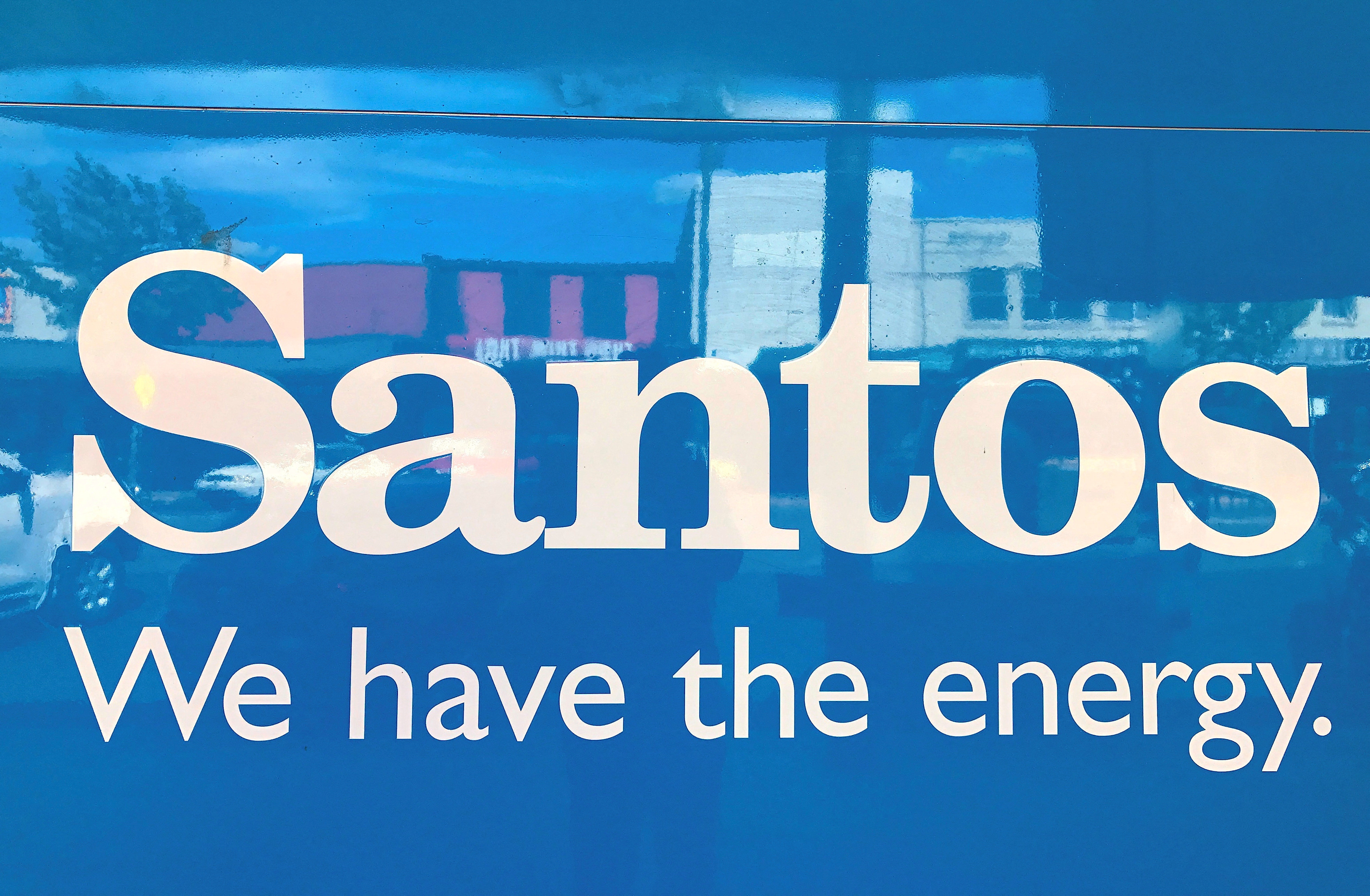 A sign for Santos Ltd is displayed on the front of a company' office building