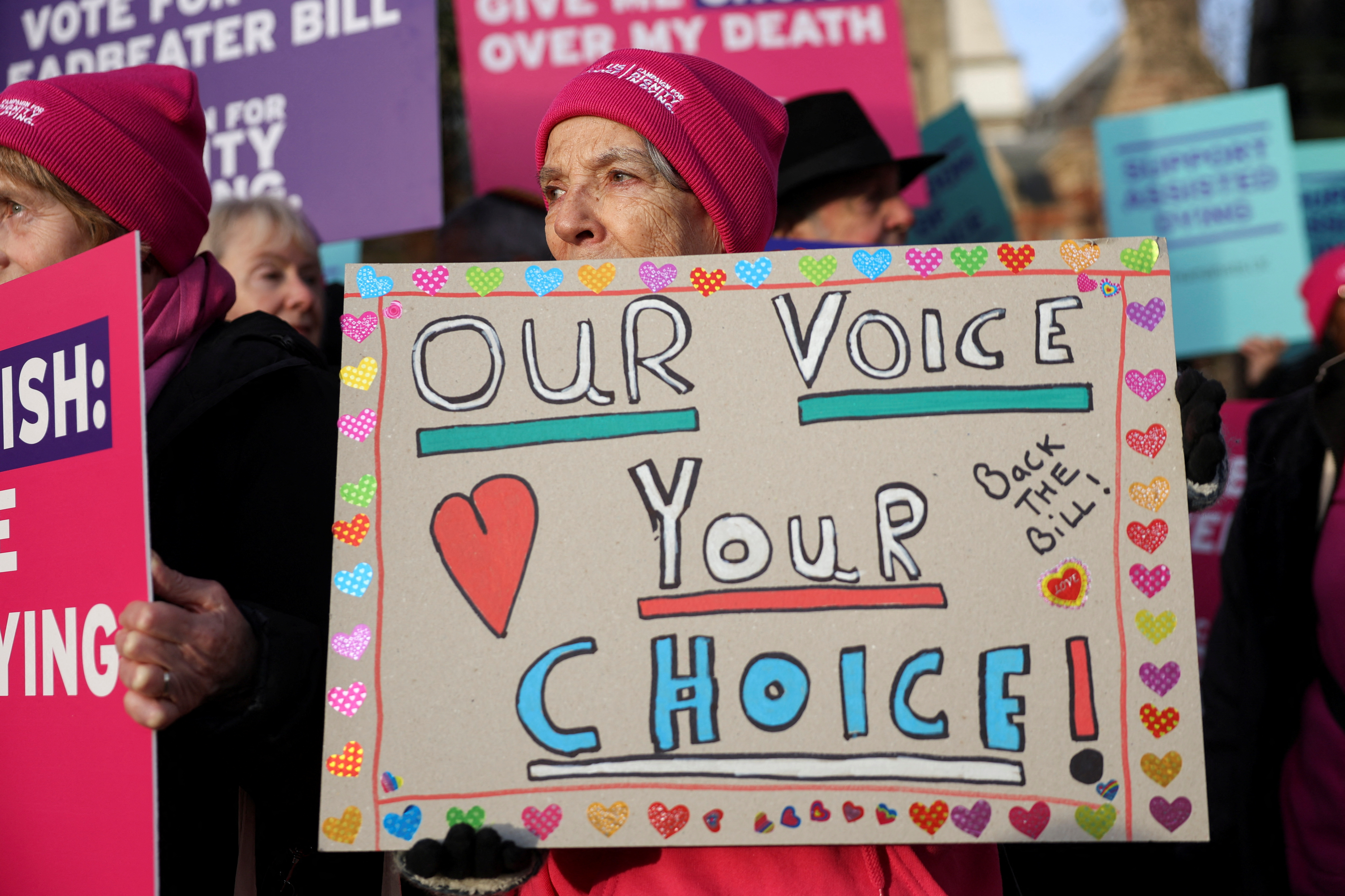 Protestors gather as British lawmakers debate the assisted dying law, in London