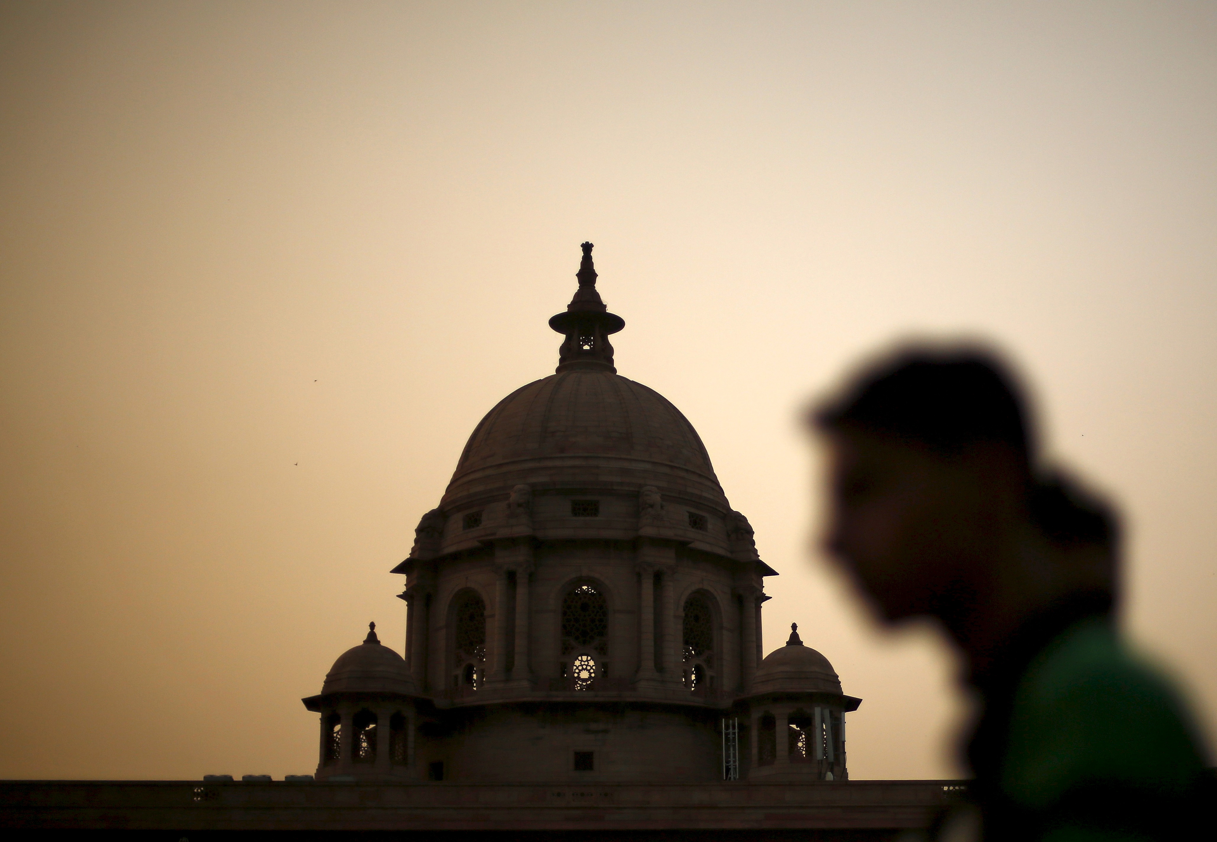 File photo of a commuter walking past building of India's Ministry of Finance during dusk in New Delhi