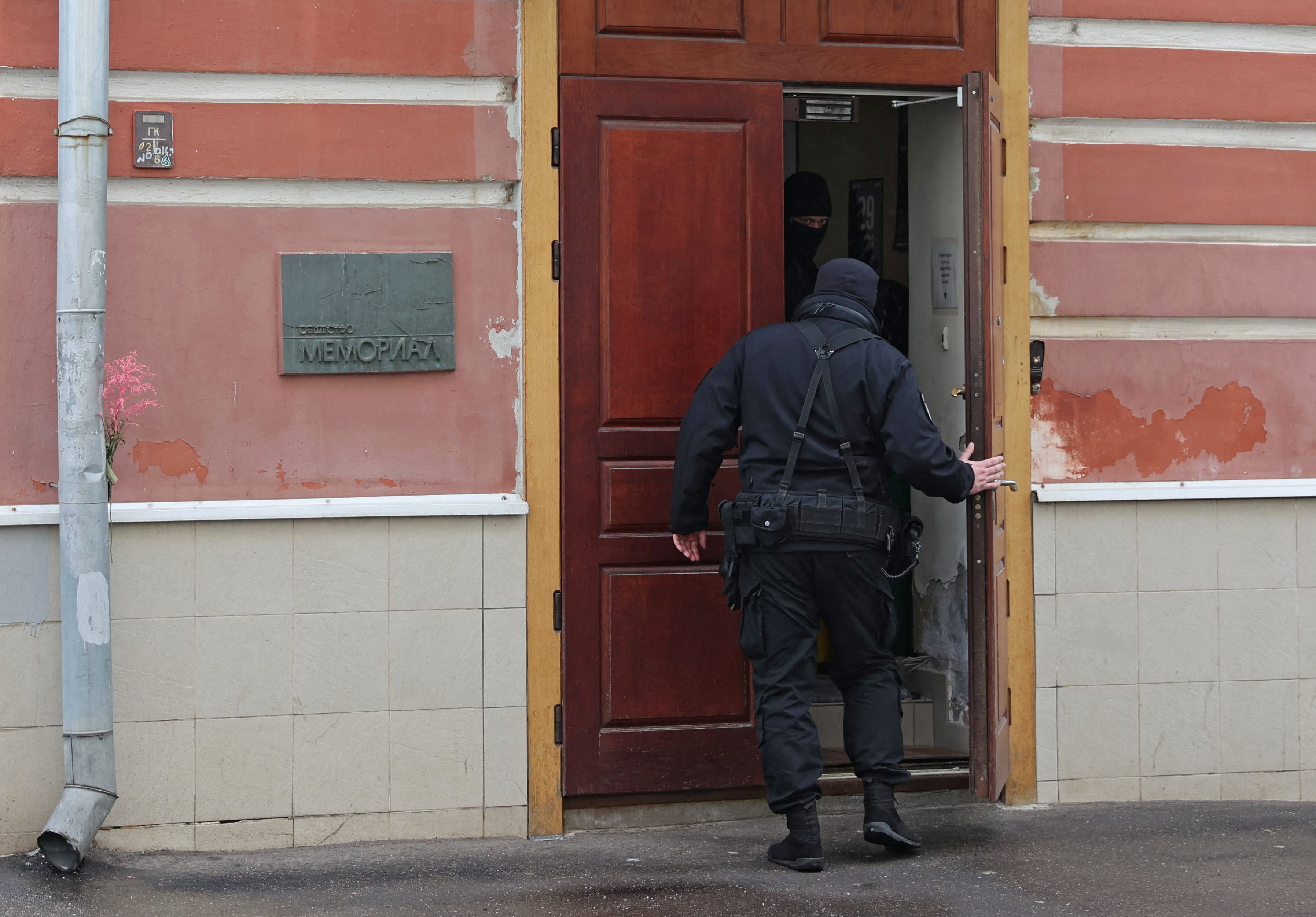 Members of Russian security forces enter the office of the human rights group Memorial during a raid in Moscow