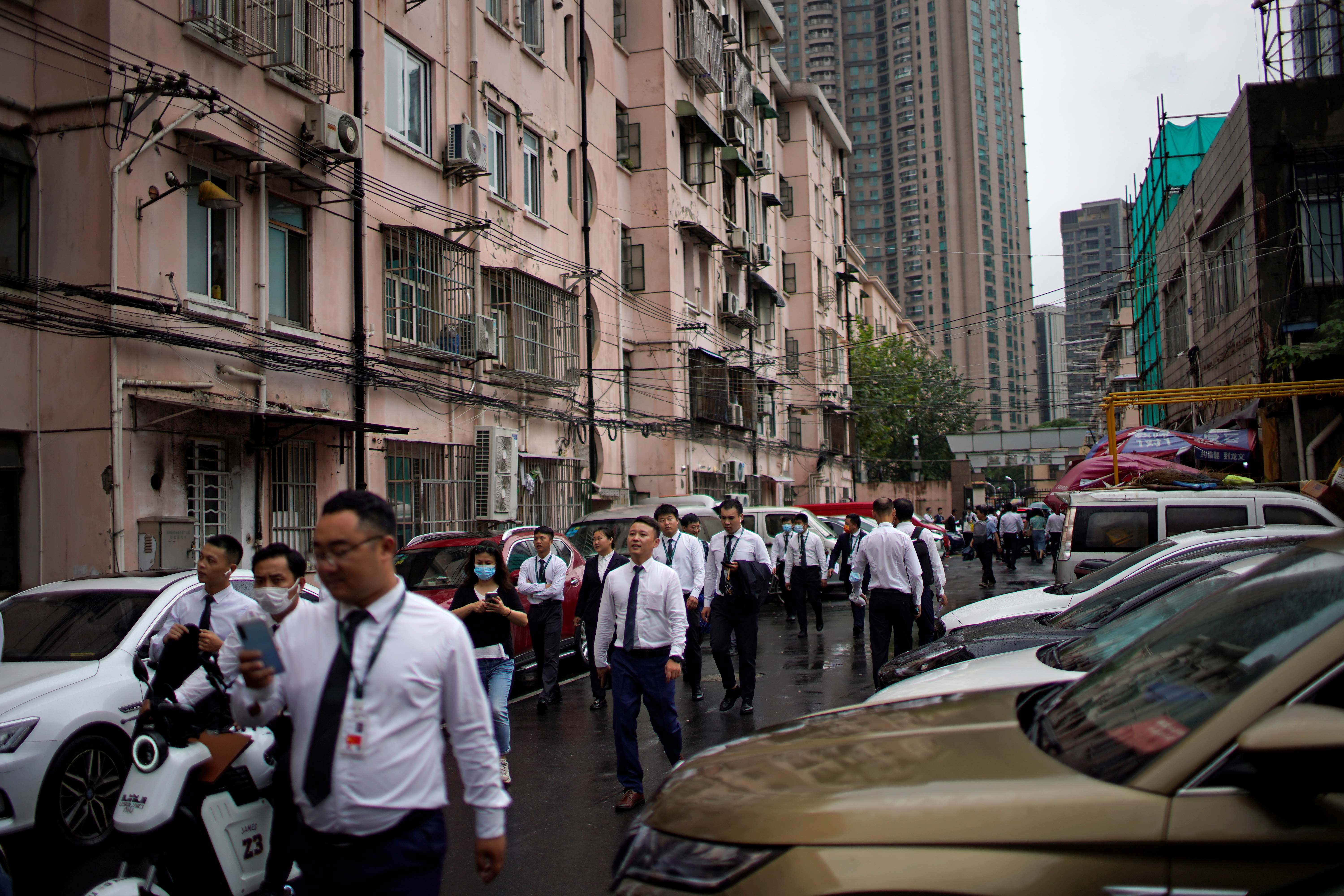 Real estate agents walk along at a residential area in Shanghai, China October 15, 2021. REUTERS/Aly Song
