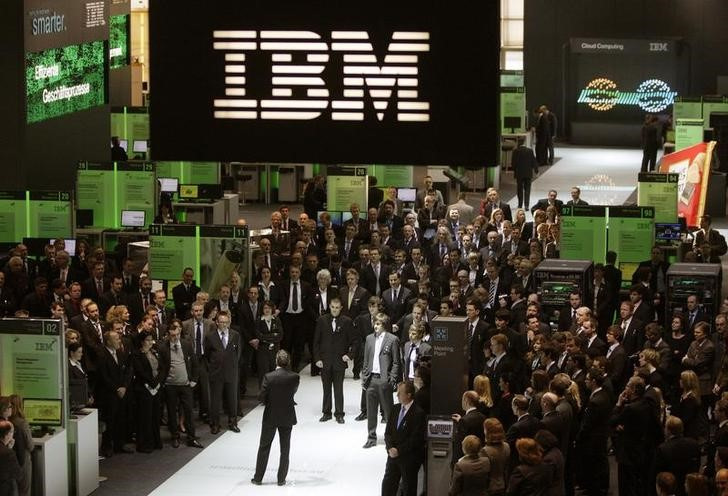 Employees follows a speech at the booth of IBM at CeBIT computer fair in Hanover