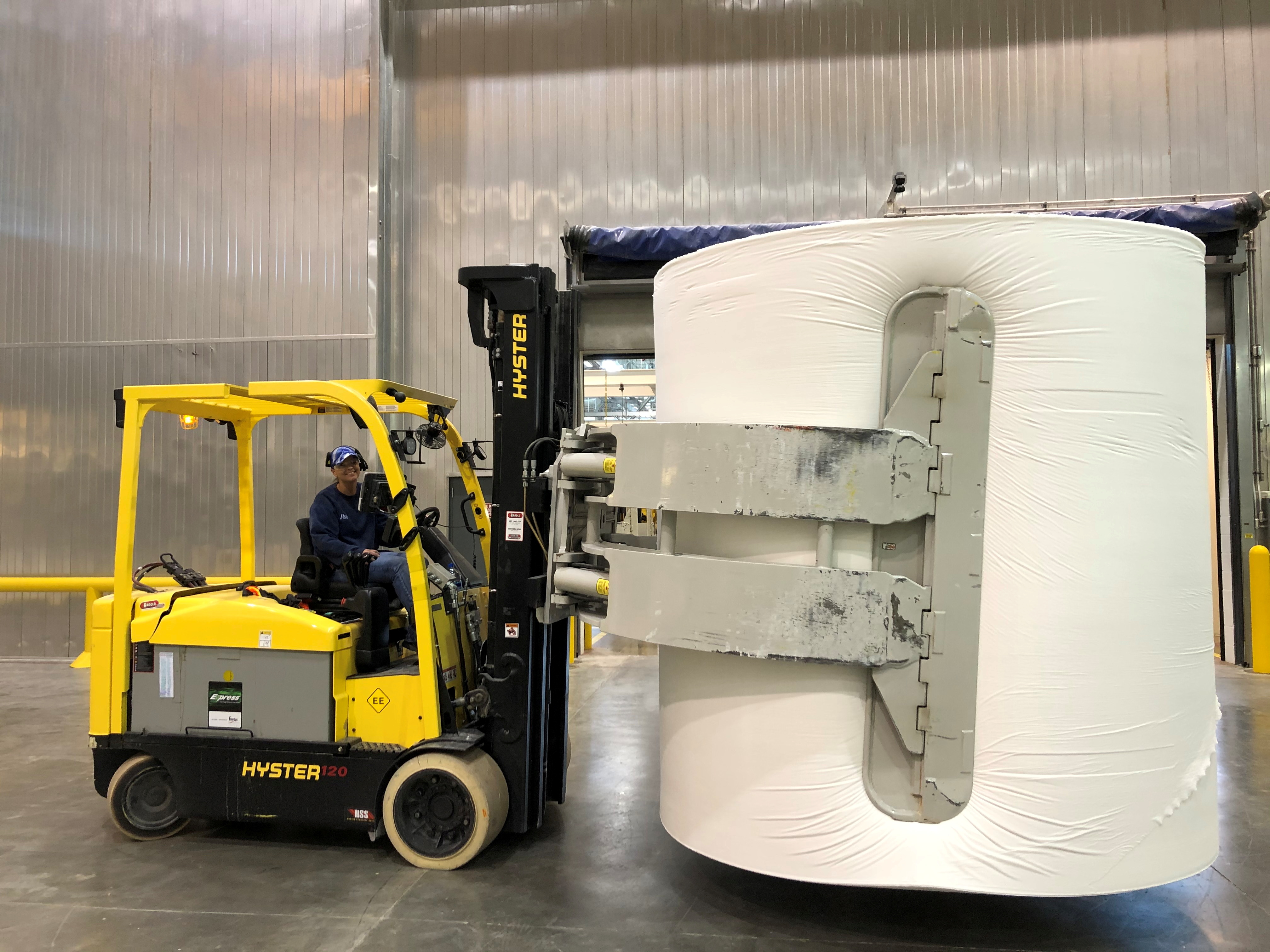 A worker at a P&G factory transports a giant roll of paper used in the production of Charmin toilet paper, in Albany, Georgia, U.S.