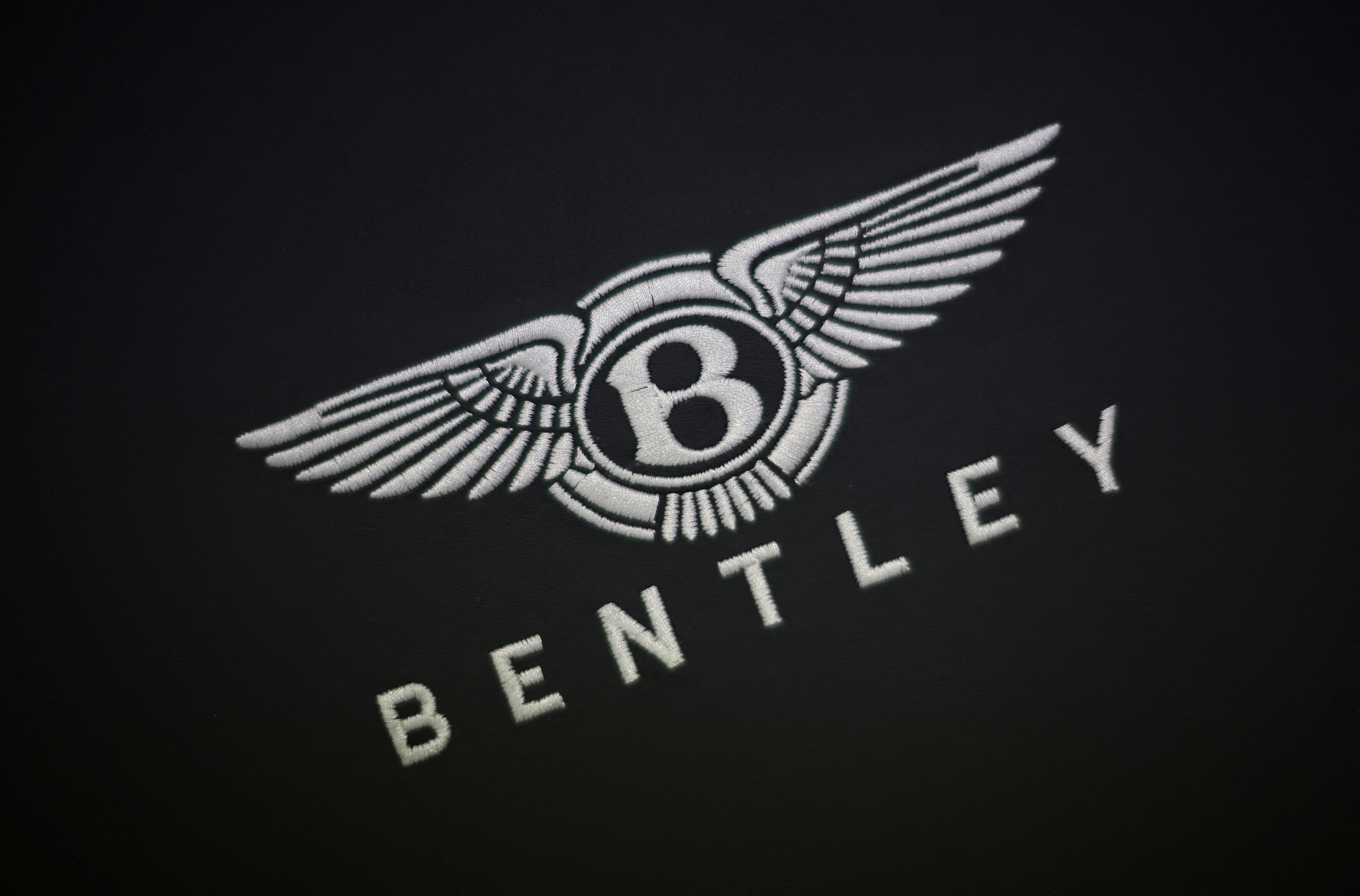 A company logo is seen stitched to a piece of leather inside the Bentley factory in Crewe