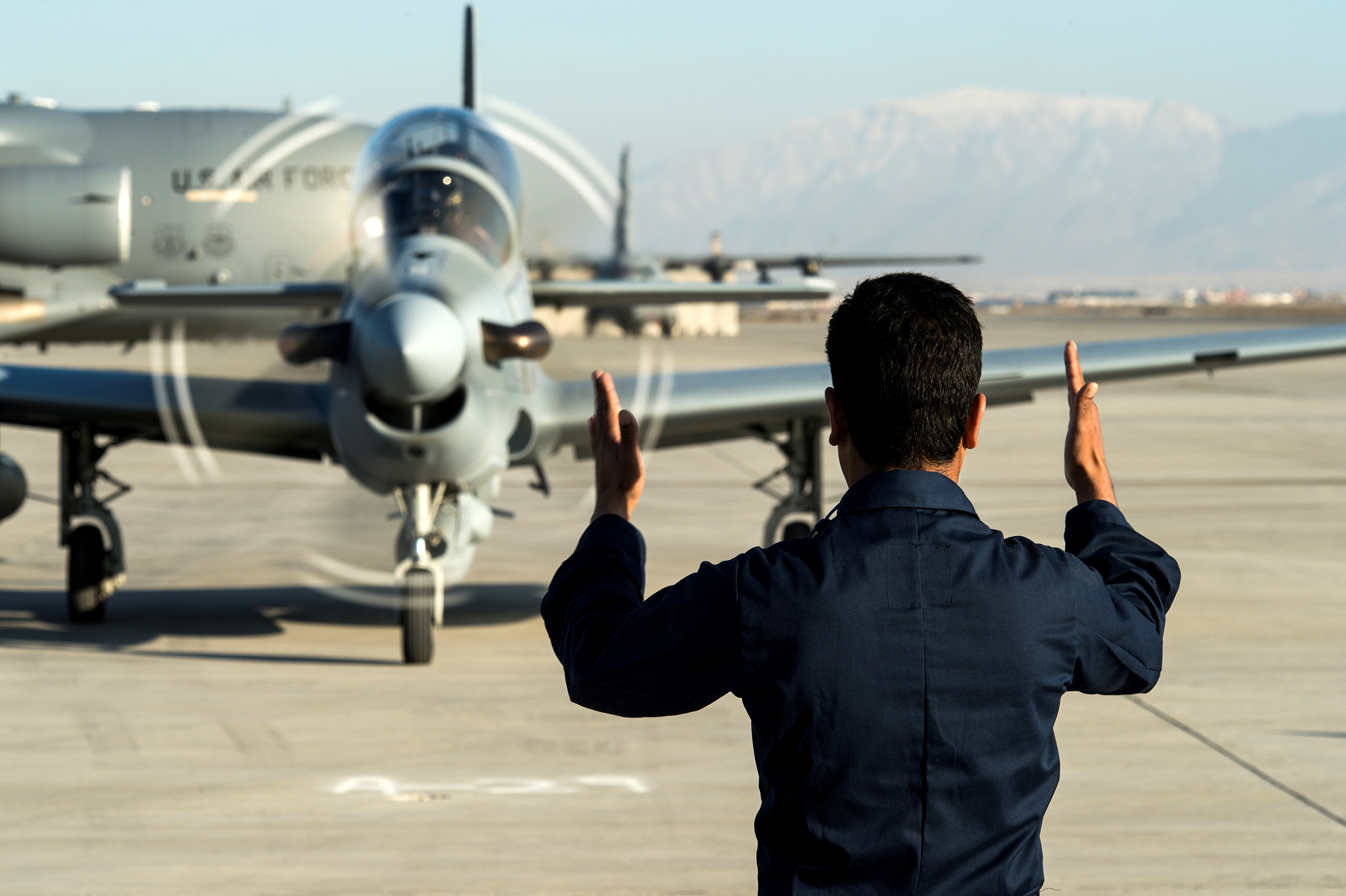 A member of the Afghan air force marshals in an A-29 Super Tucano at Hamid Karzai International Airport near Kabul, Afghanistan, January 15, 2016. Picture taken January 15, 2016. To match Special Report USA-AFGHANISTAN/PILOTS  U.S. Air Force/Tech. Sgt. Nathan Lipscomb/Handout via REUTERS/File Photo
