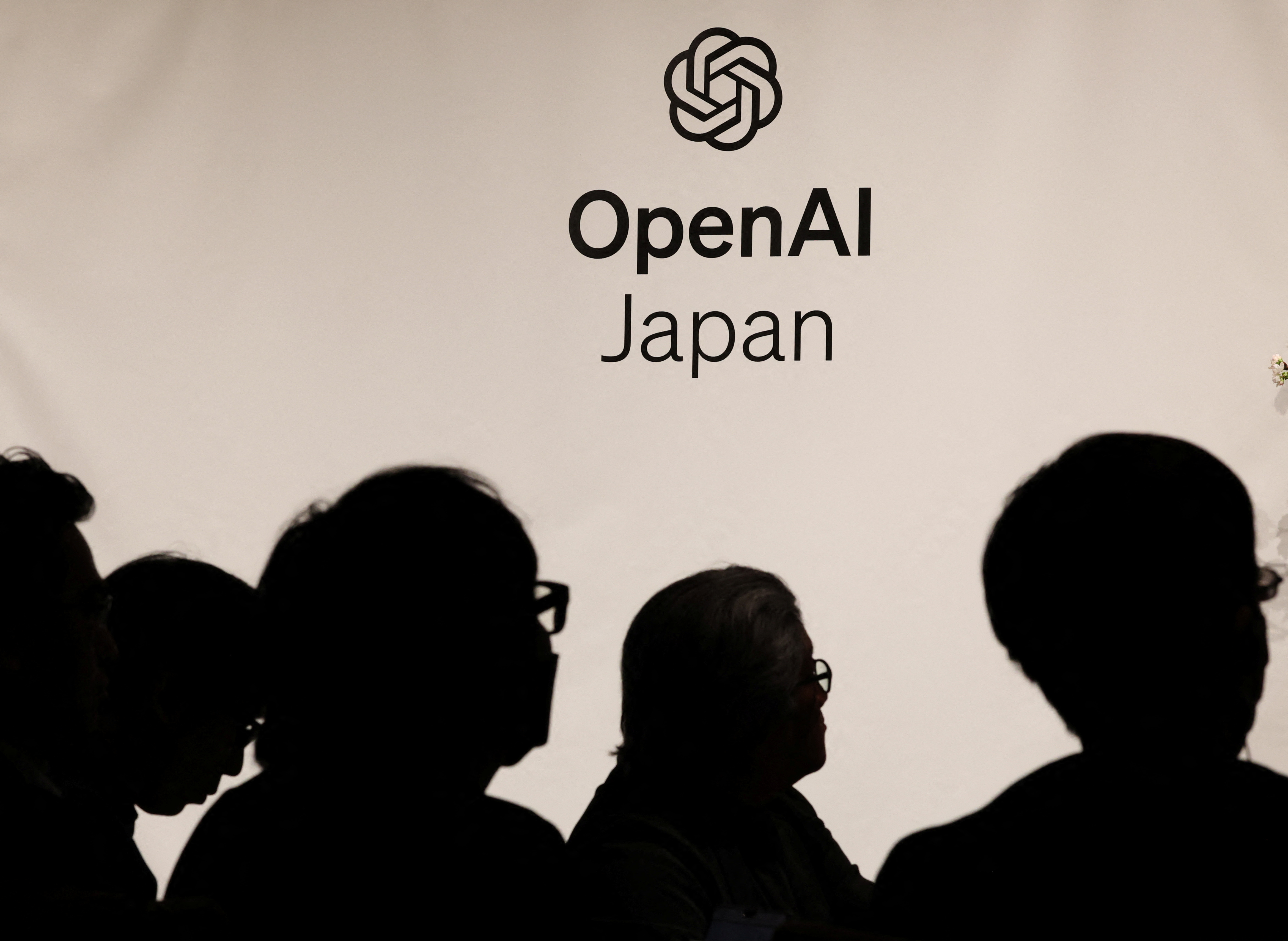 Journalists are silhouetted at OpenAI’s press conference about the opening of its first Asia office in Tokyo