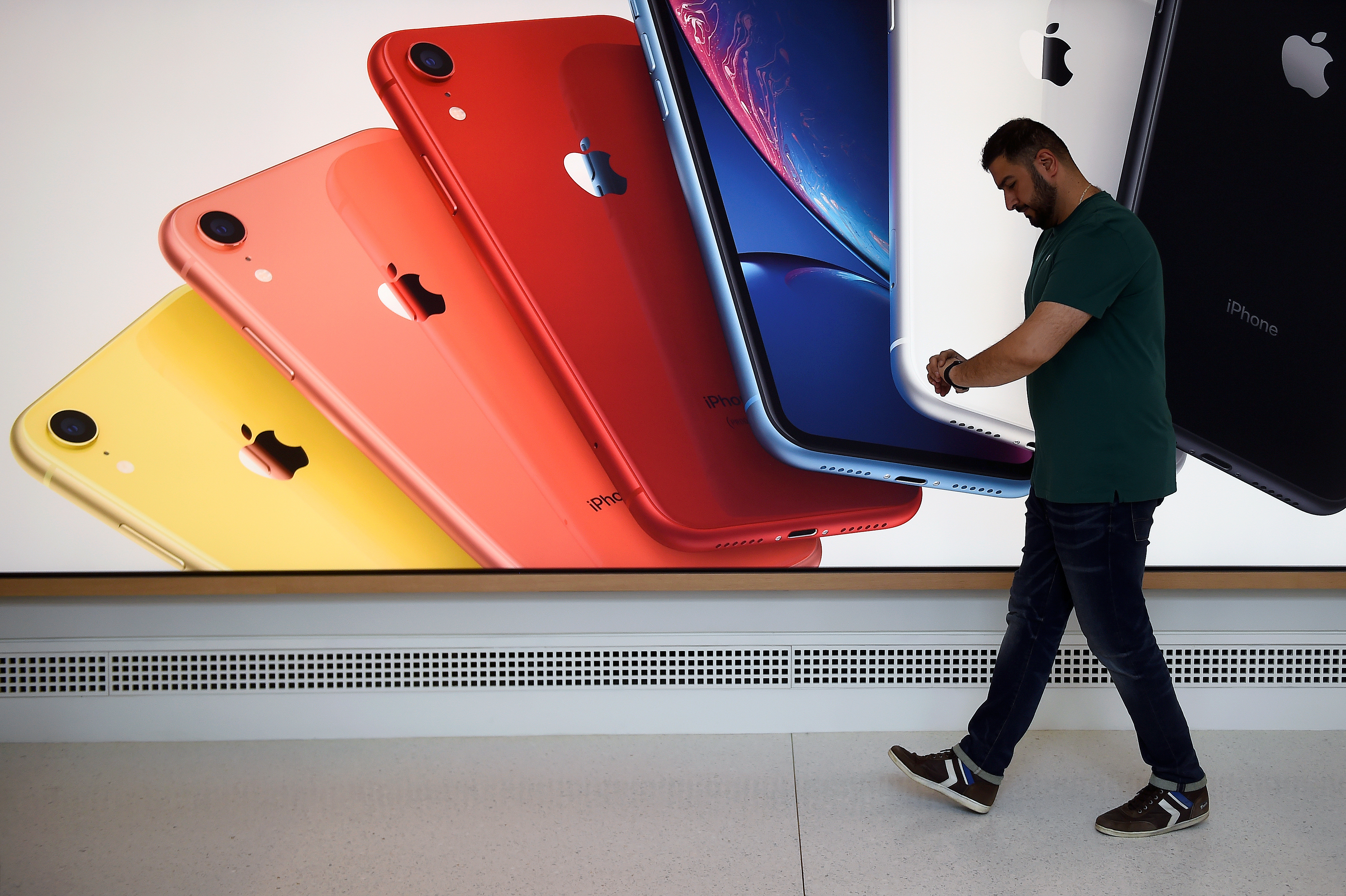 An Apple Store employee checks their Apple Watch during the grand opening and media preview of the new Apple Carnegie Library store in Washington