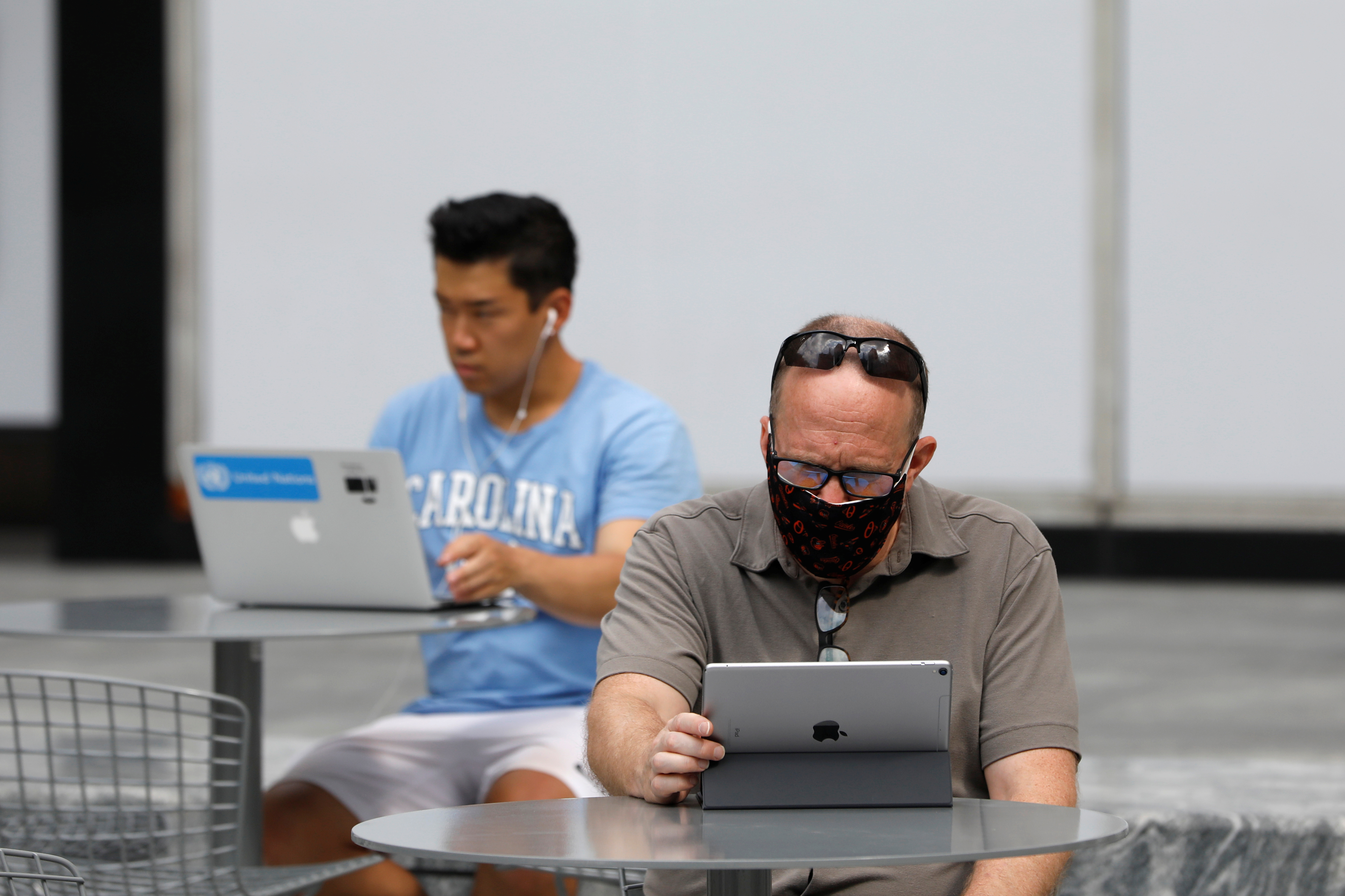 People use an Apple laptop computer and an Apple iPad in Manhattan, New York City