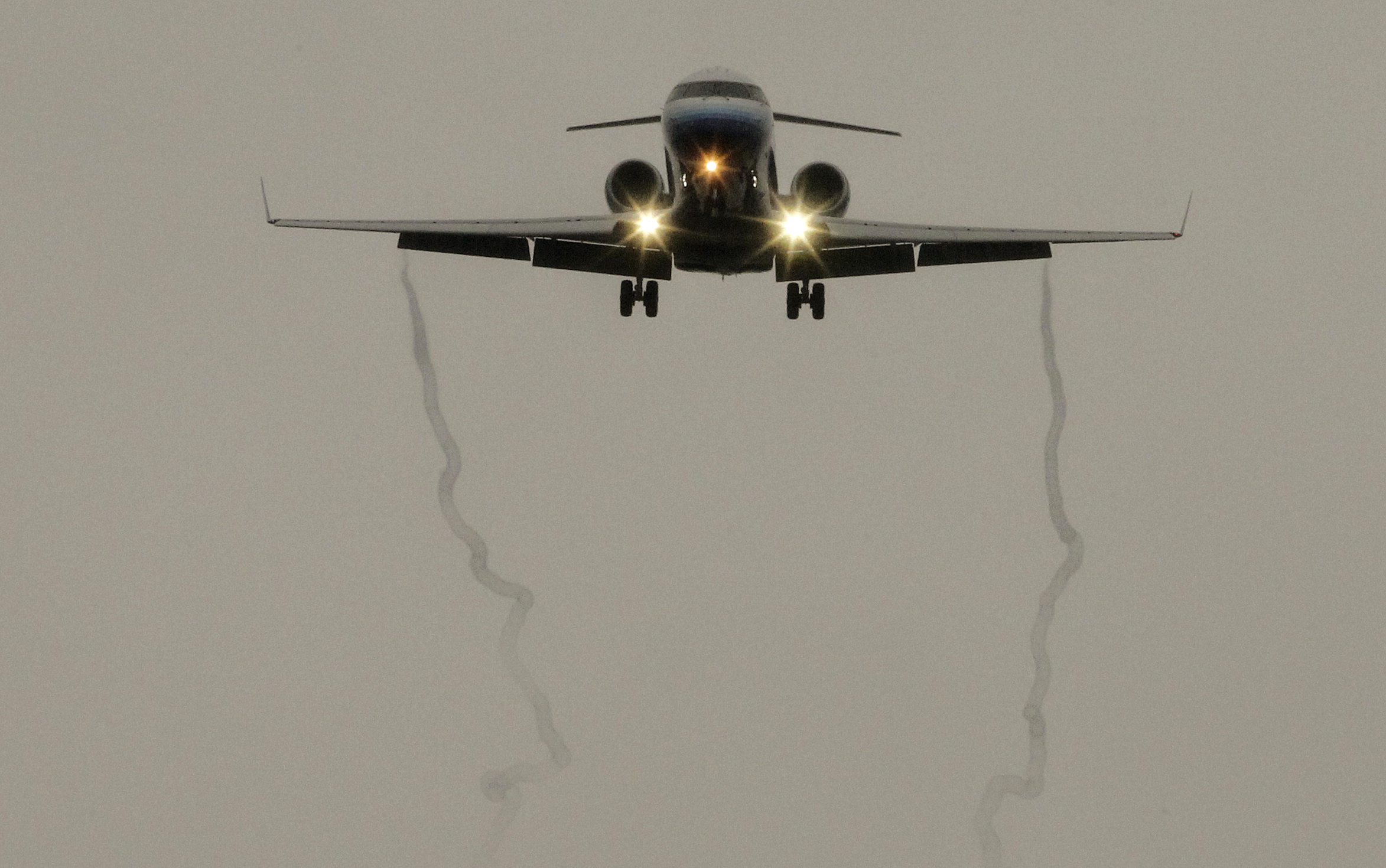 Contrails form on the wings of a passenger jet aircraft as it lands in the rain at Los Angeles International Airport in Los Angeles