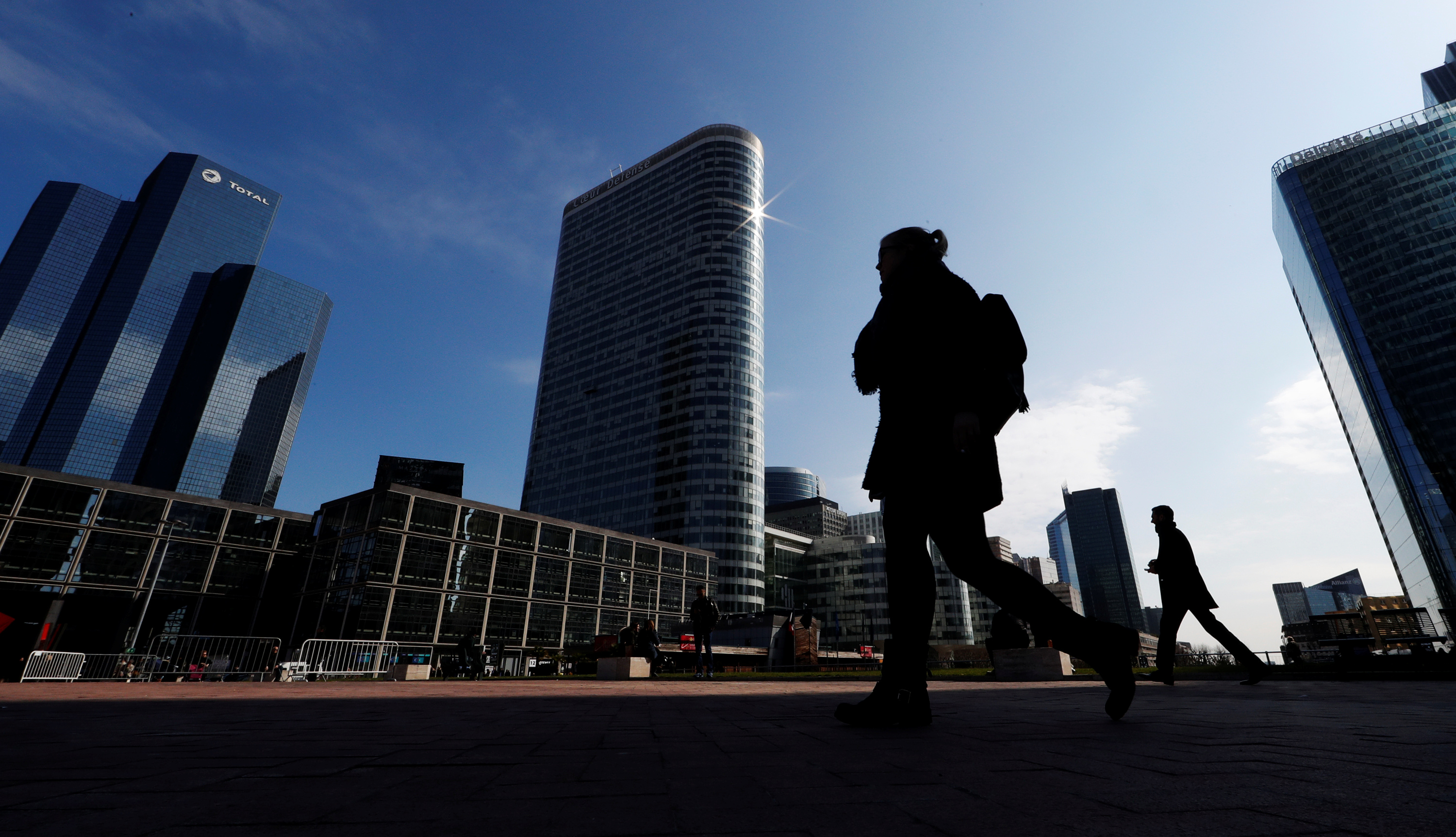 People walk on the esplanade of La Defense in the financial and business district of La Defense, west of Paris