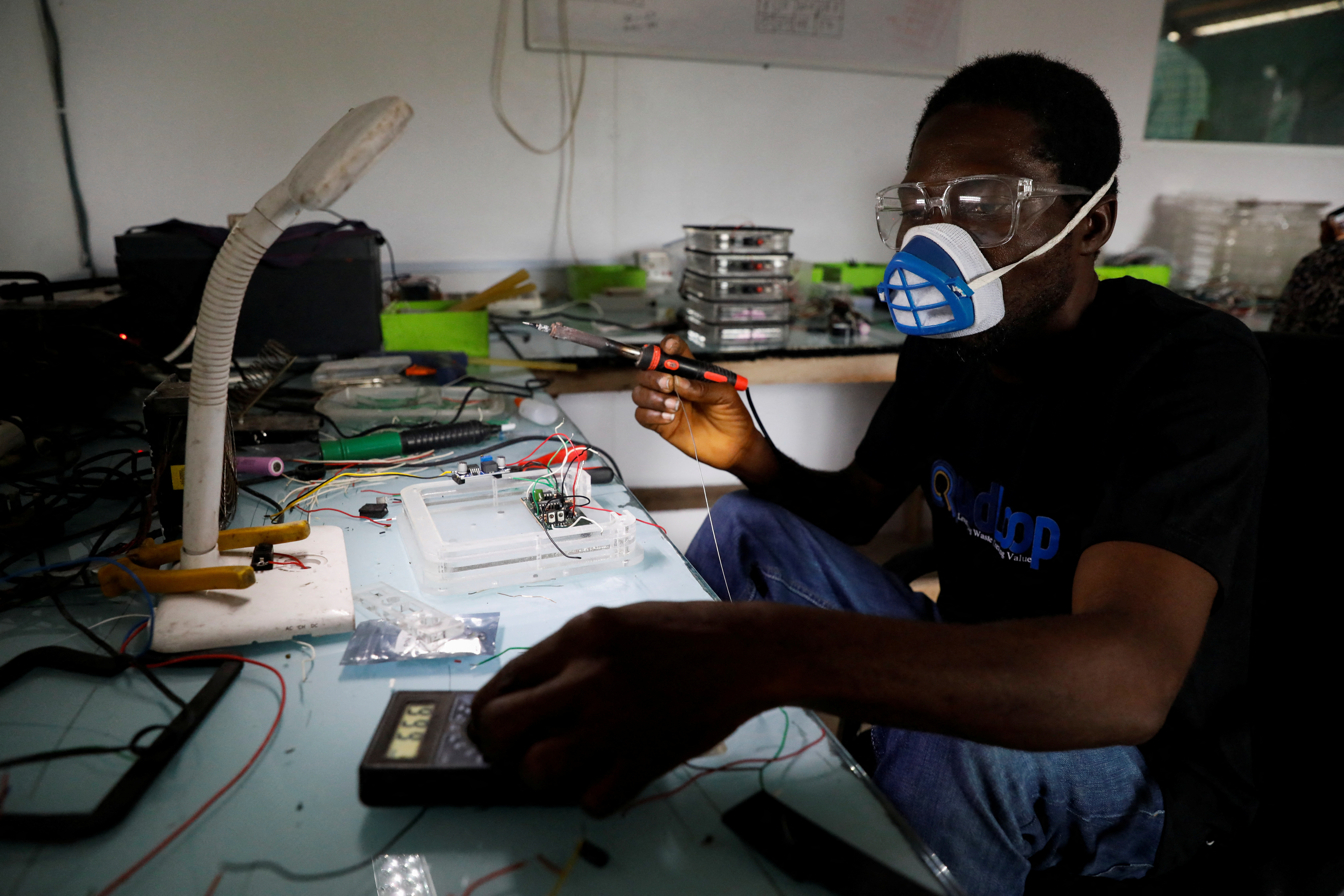 An employee works on the production of solar lanterns from recycled electronic waste at Quadloop recycling facility in Lagos