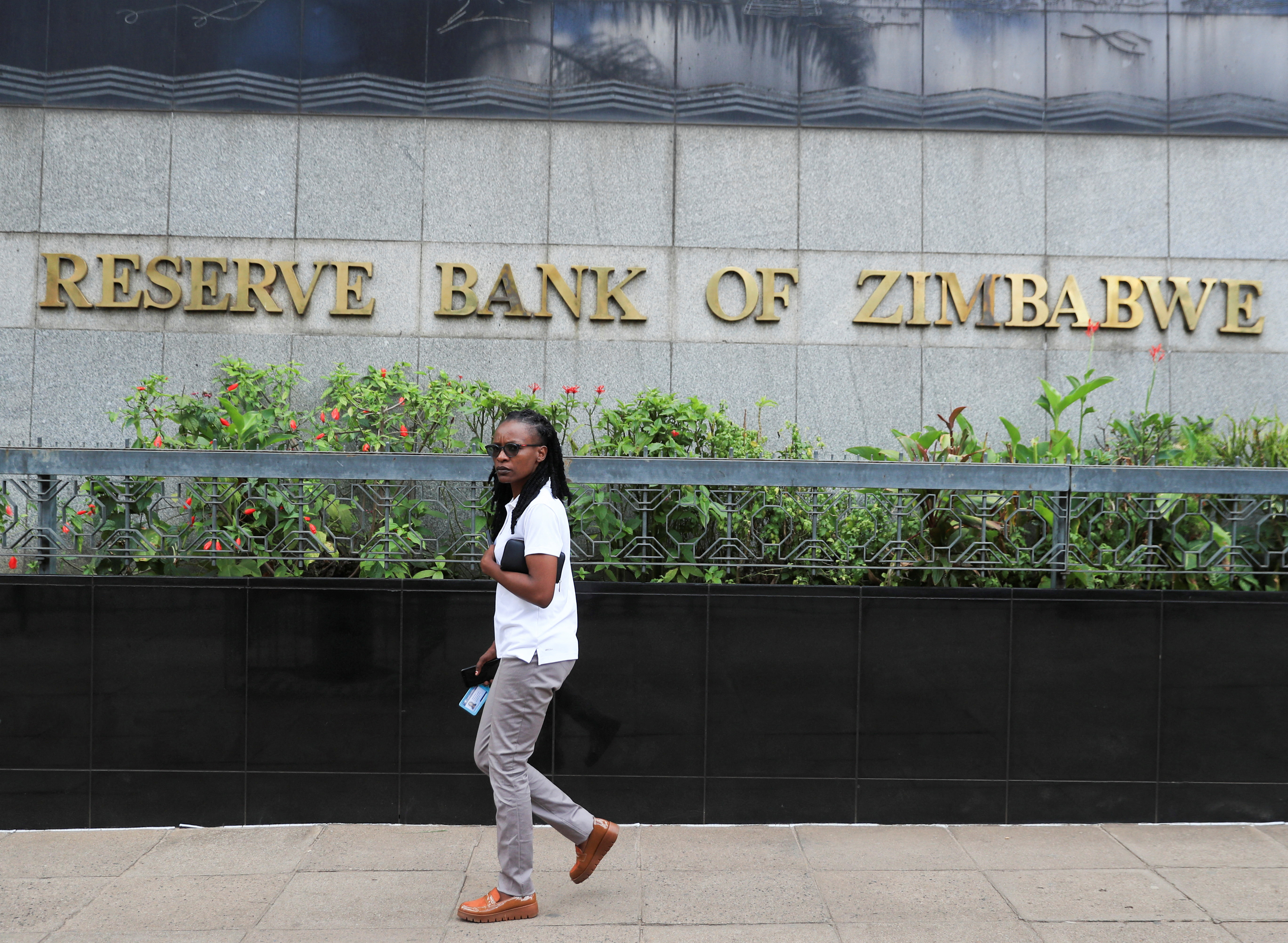 A woman walks past the Reserve Bank of Zimbabwe building in Harare