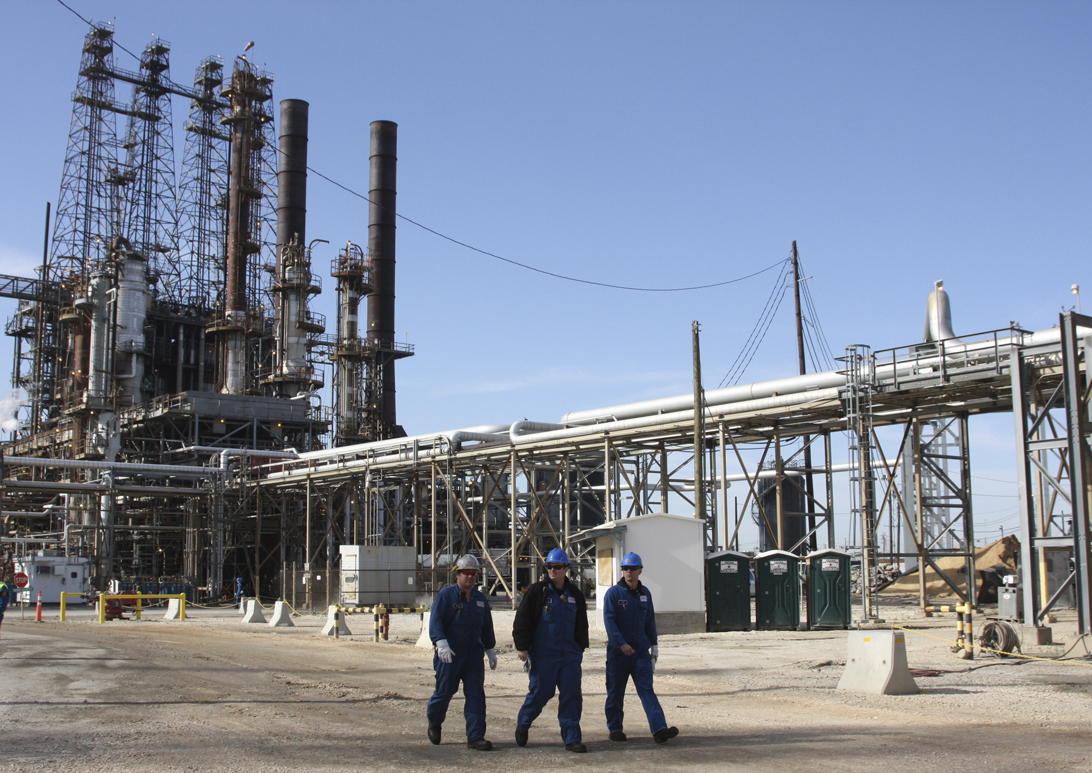 Refinery workers walk inside the LyondellBasell oil refinery in Houston