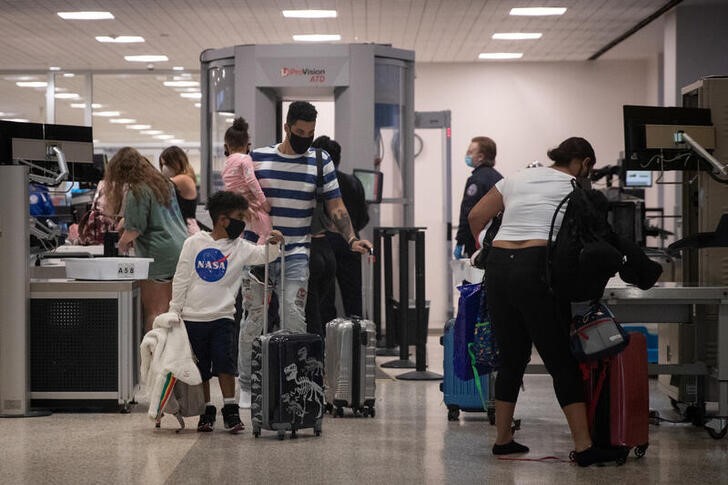 A family wears face masks after passing security at IAH George Bush Intercontinental Airport in Houston