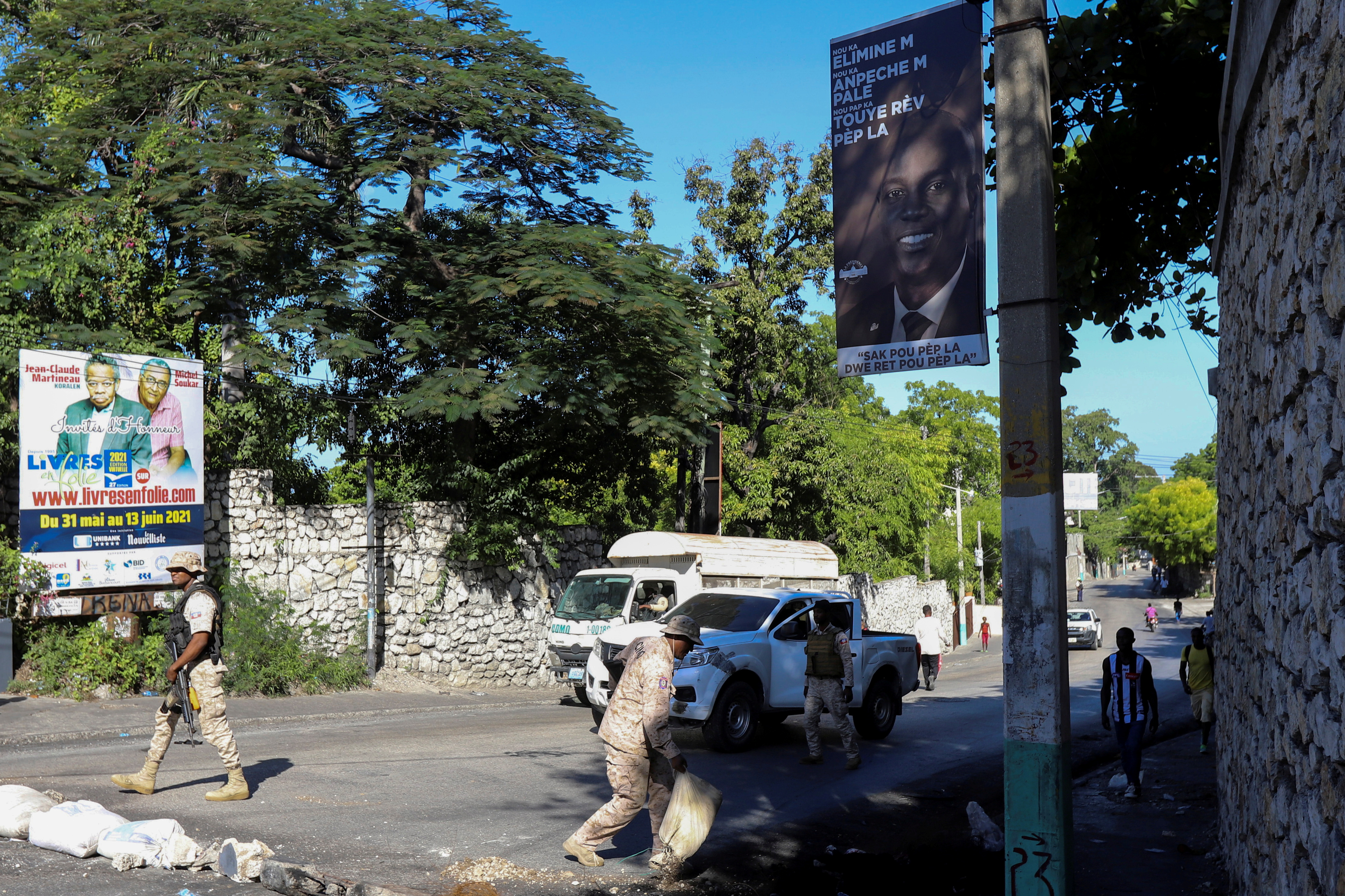 A sign with an image of assassinated President Jovenel Moise is seen as members of the Haitian National Police clear a street blockade set up in protest of insecurity and fuel shortages, in Port-au-Prince, Haiti October 25, 2021. REUTERS/Ralph Tedy Erol