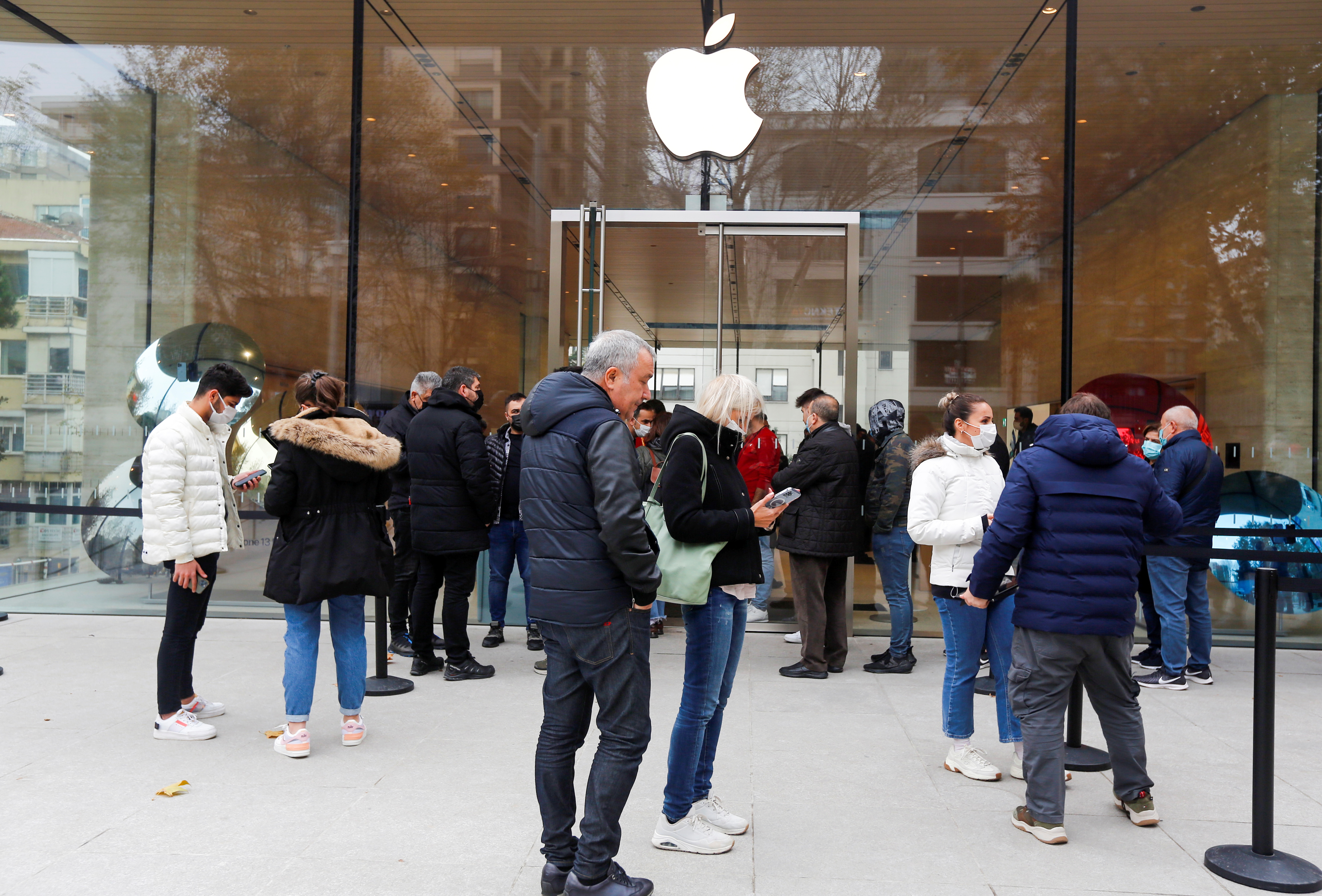 People wait in line to enter an Apple store in Istanbul