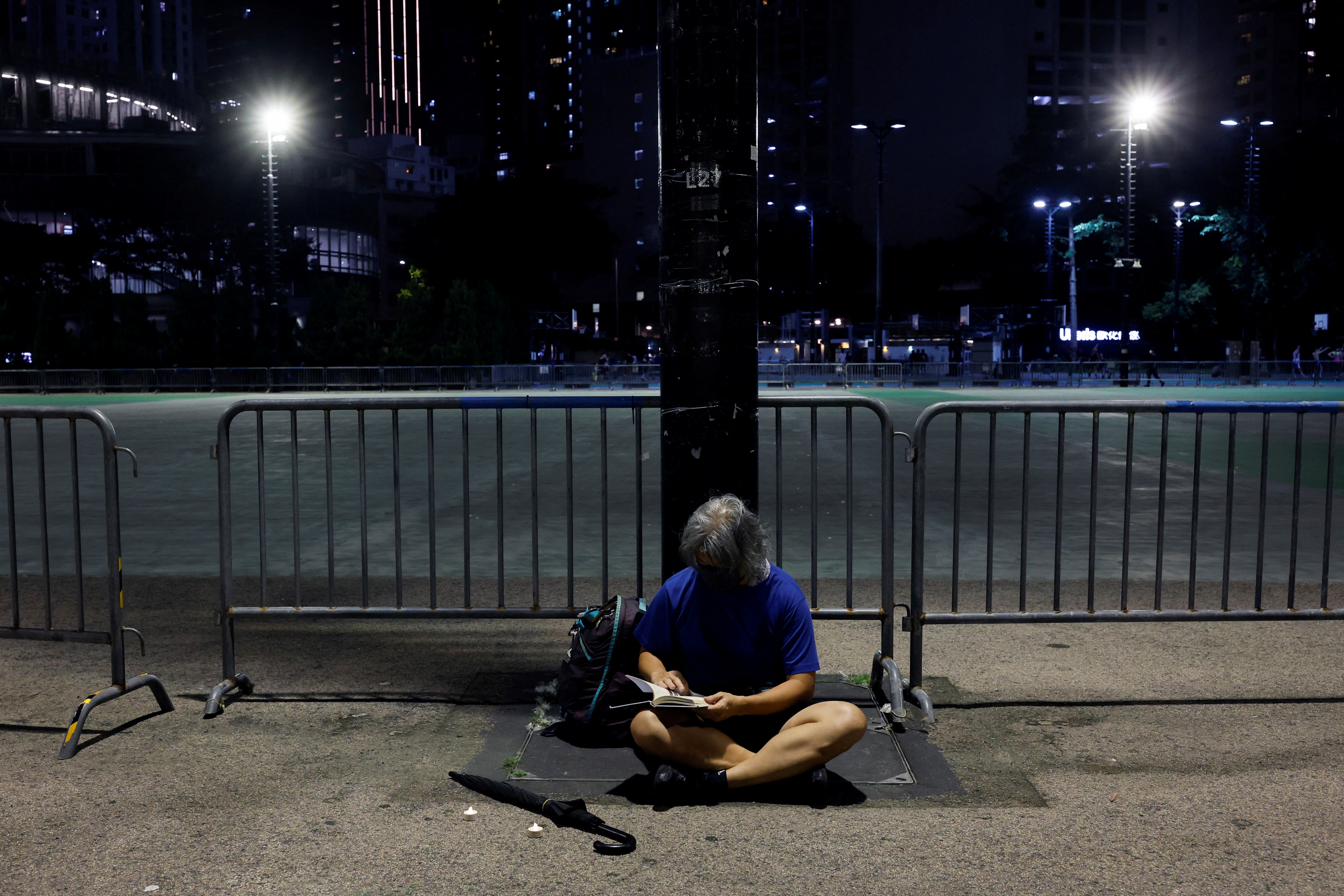 A man sits beside electric candles placed by him at Victoria Park, ahead of Tiananmen anniversary, in Hong Kong