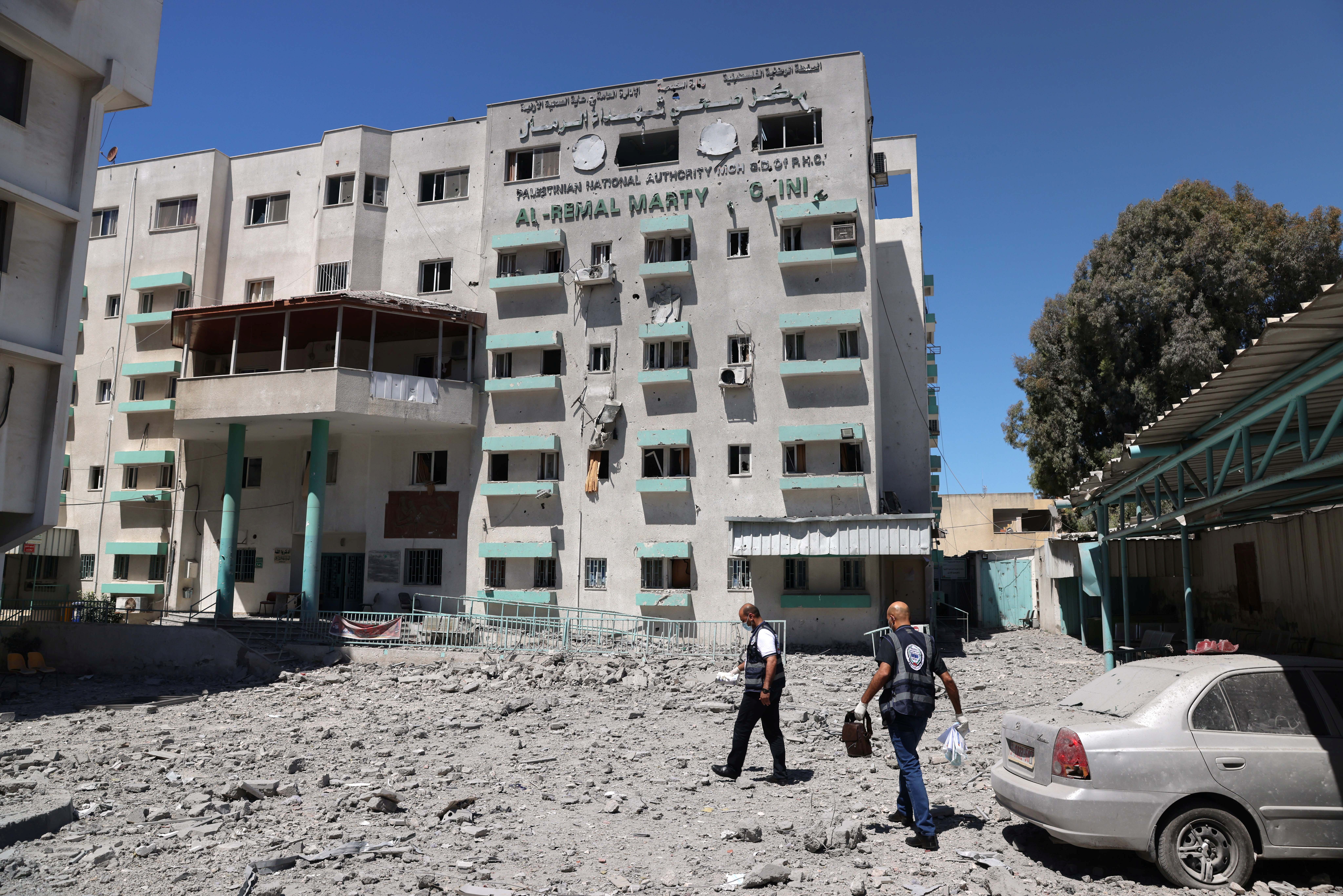 Palestinian medics walk at the damaged health ministry headquarters in the aftermath of Israeli air strikes, in Gaza City