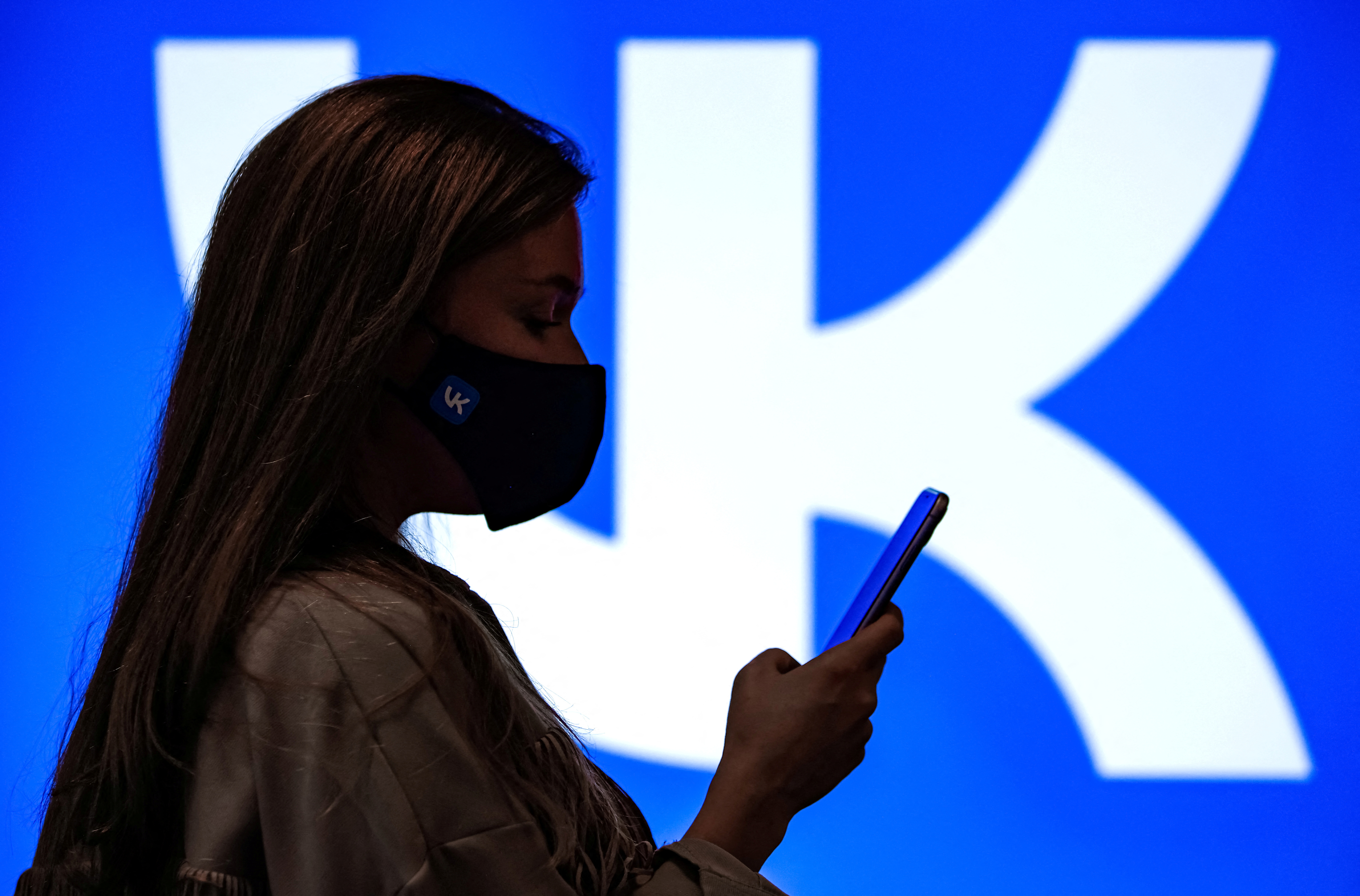 An employee of Russian internet company VK uses her smartphone at the company's headquarters in Moscow