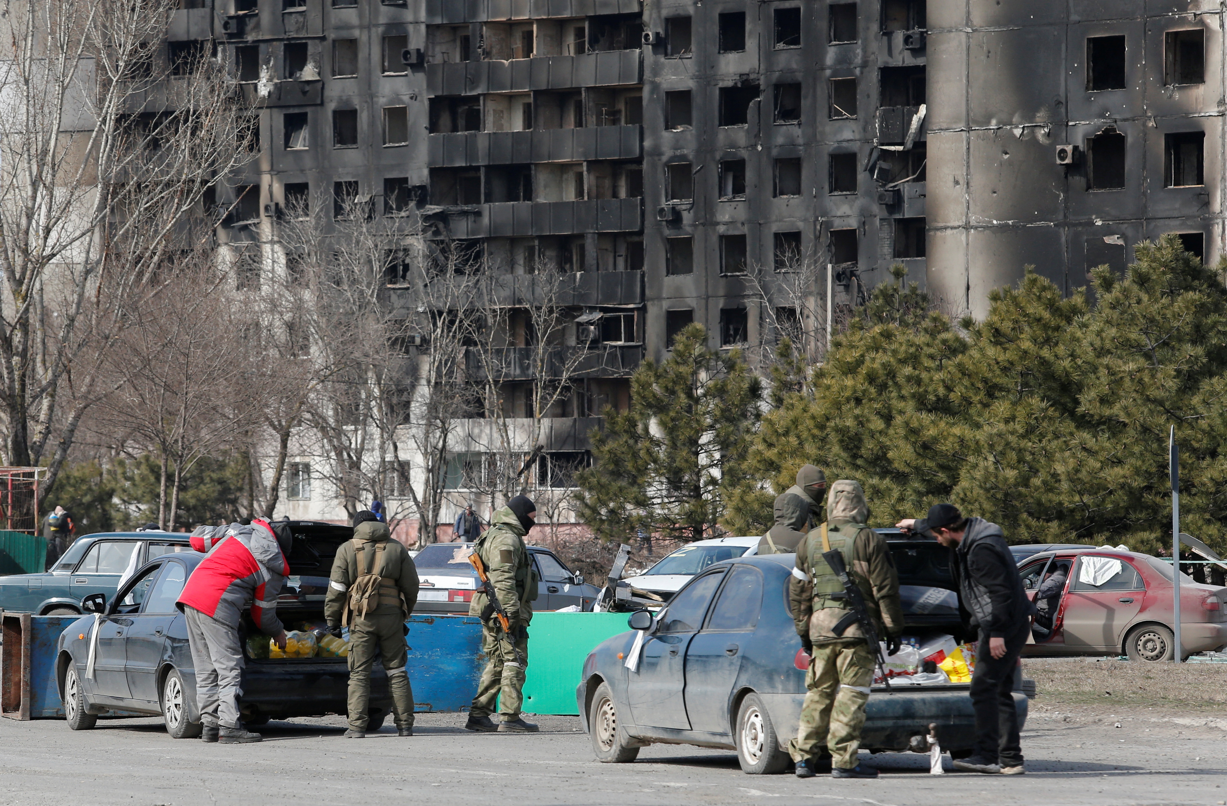 Service members of pro-Russian troops check cars in the besieged city of Mariupol