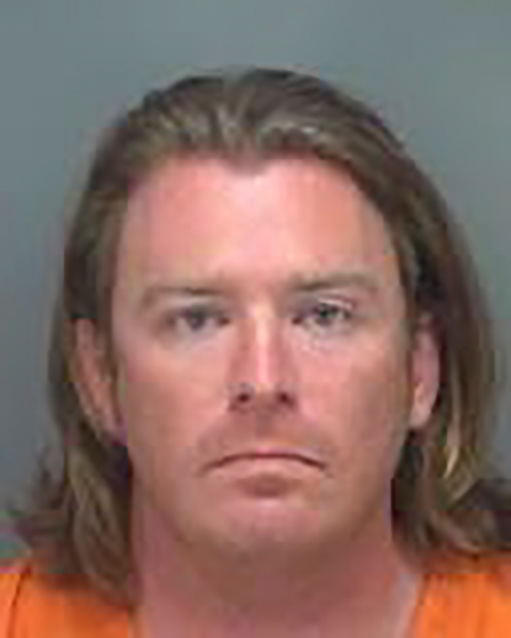 Adam Christian Johnson, who was arrested on a federal warrant, poses in a Pinellas County jail booking photograph