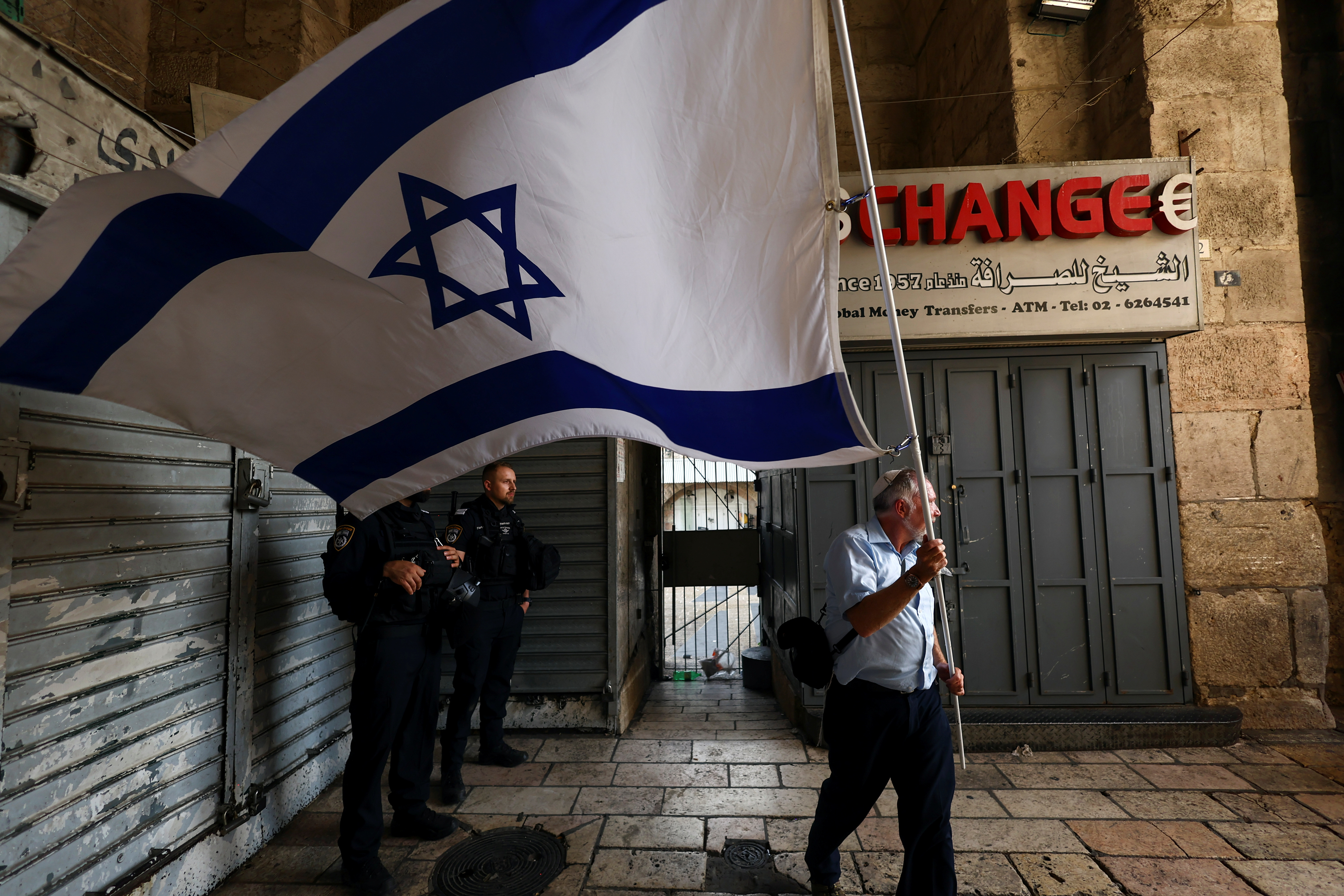 An Israeli man waves a giant flag as he enters Damascus Gate to Jerusalem's Old city