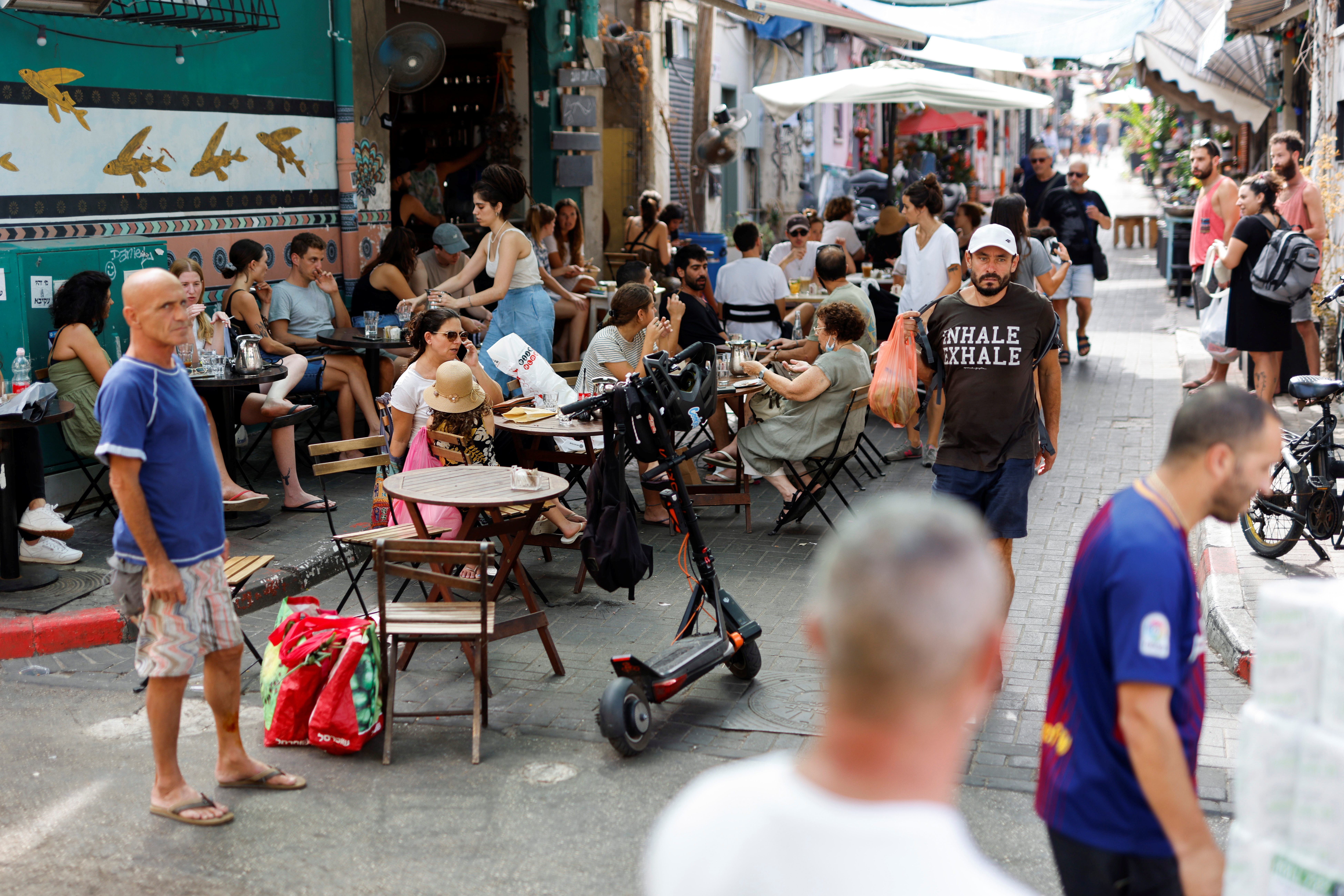 People sit at an outdoor cafe near the Carmel Market as coronavirus disease (COVID-19) restrictions ease in Tel Aviv