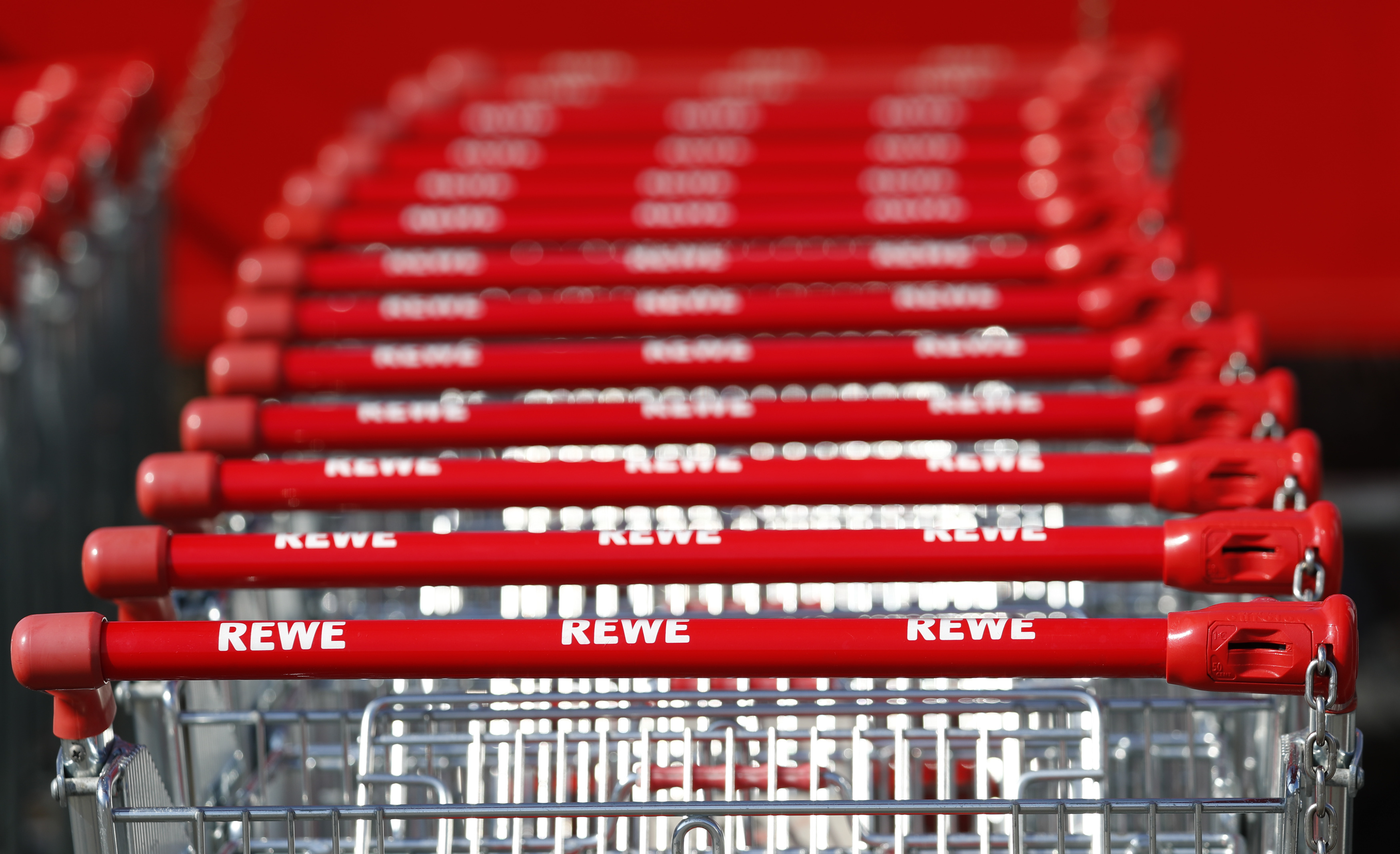 Shopping carts with logos of German supermarket chain Rewe are pictured at a shopping centre in Hanau