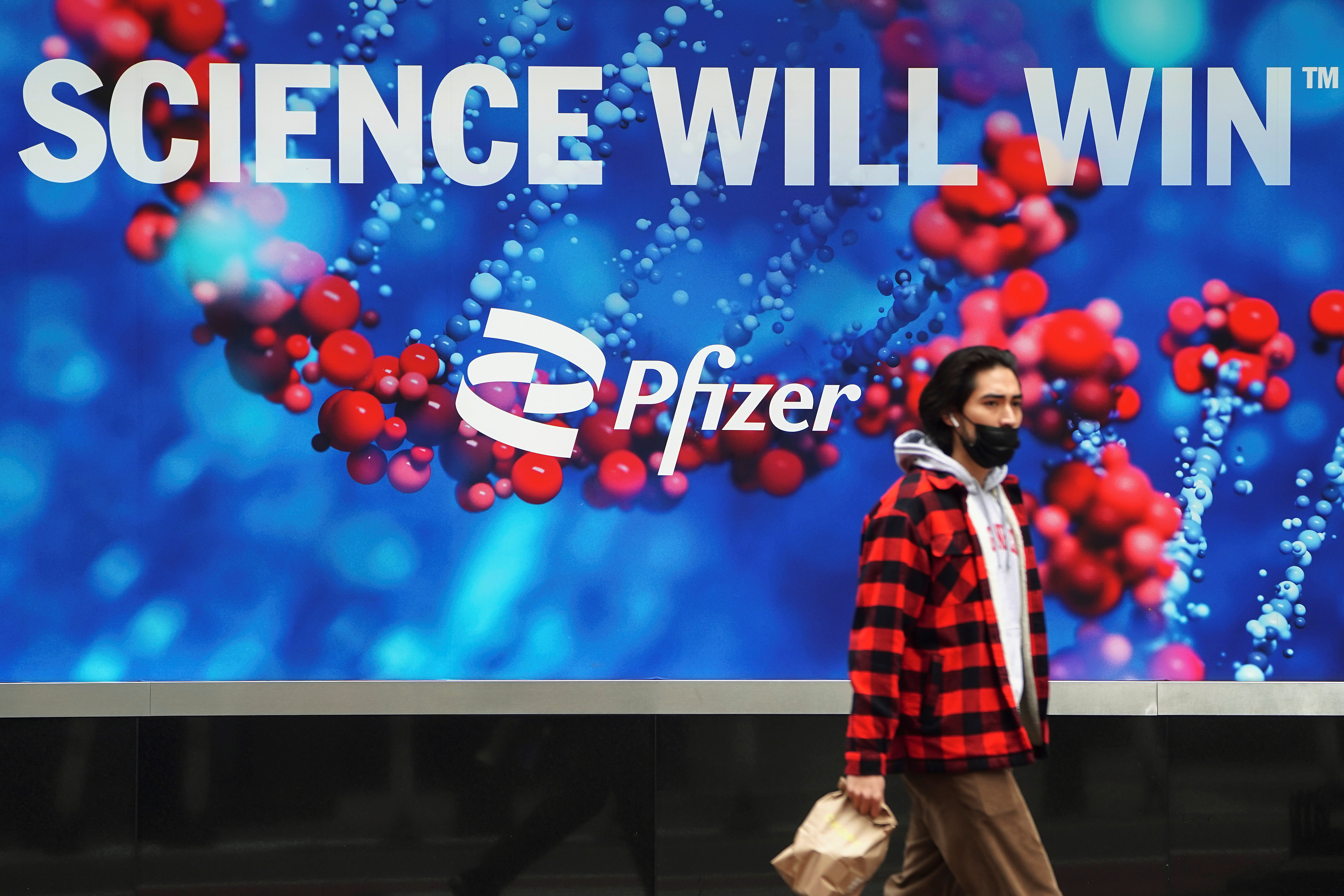 A person walks past a Pfizer sign in New York City