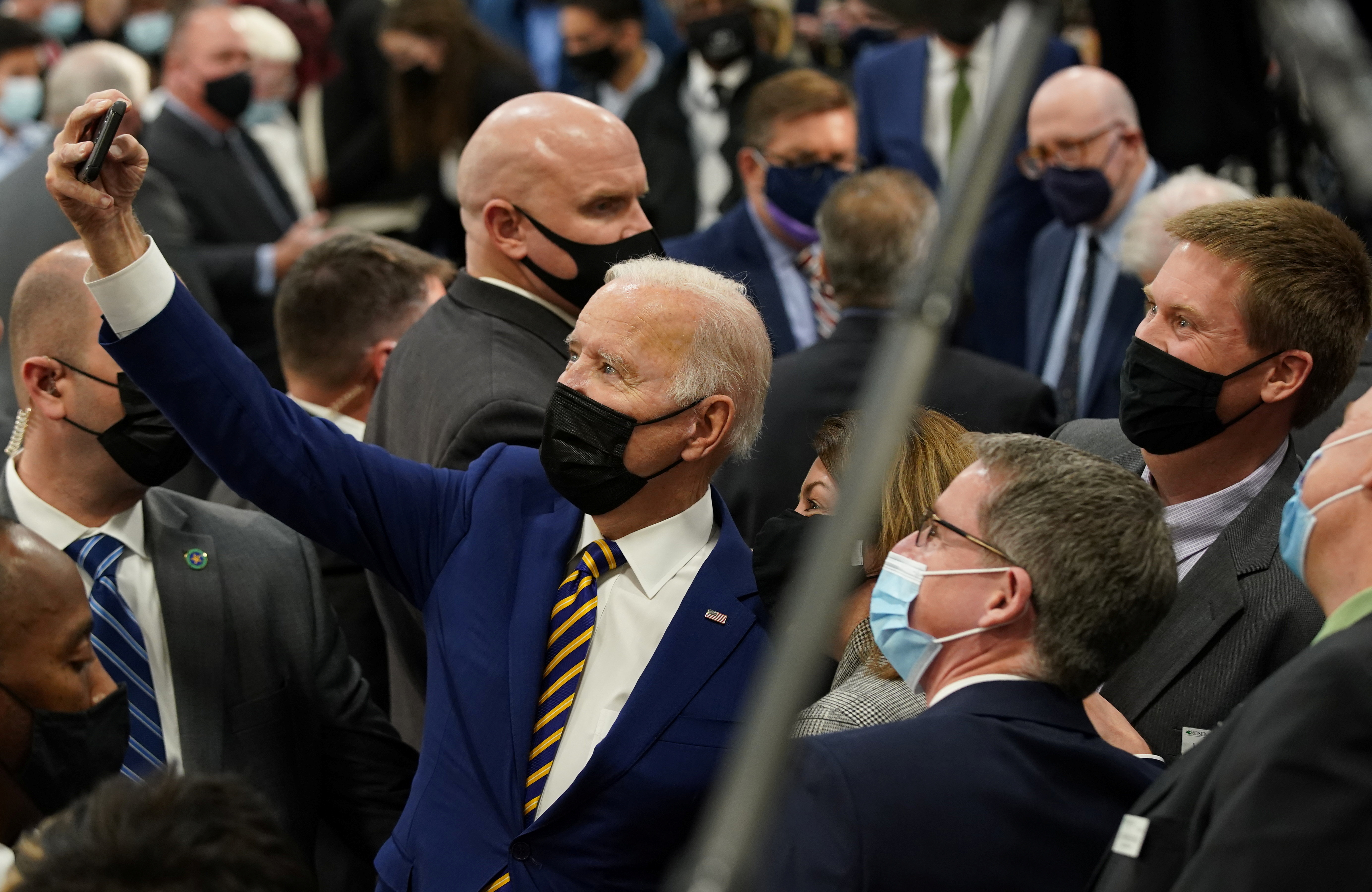 U.S. President Joe Biden takes selfie photos with attendees after speaking about the Bipartisan Infrastructure Law, at the Dakota County Technical College, in Rosemount, Minnesota, U.S., November 30, 2021.  REUTERS/Kevin Lamarque