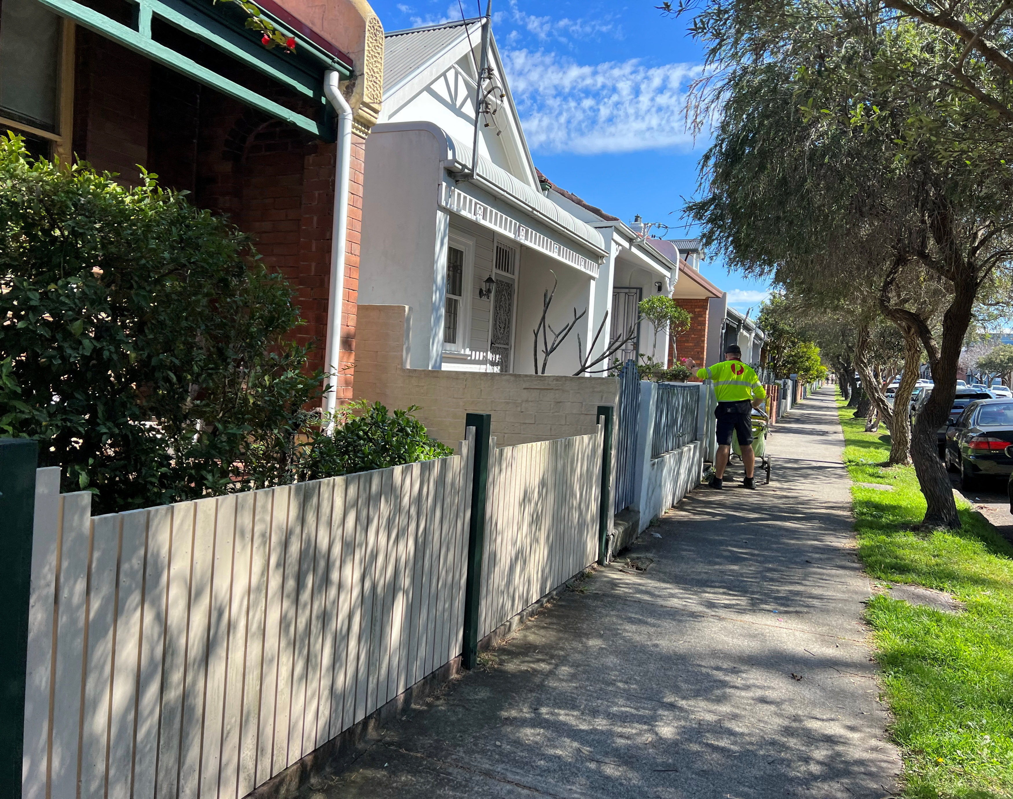 A post office worker delivers mail to townhouses in Leichhardt