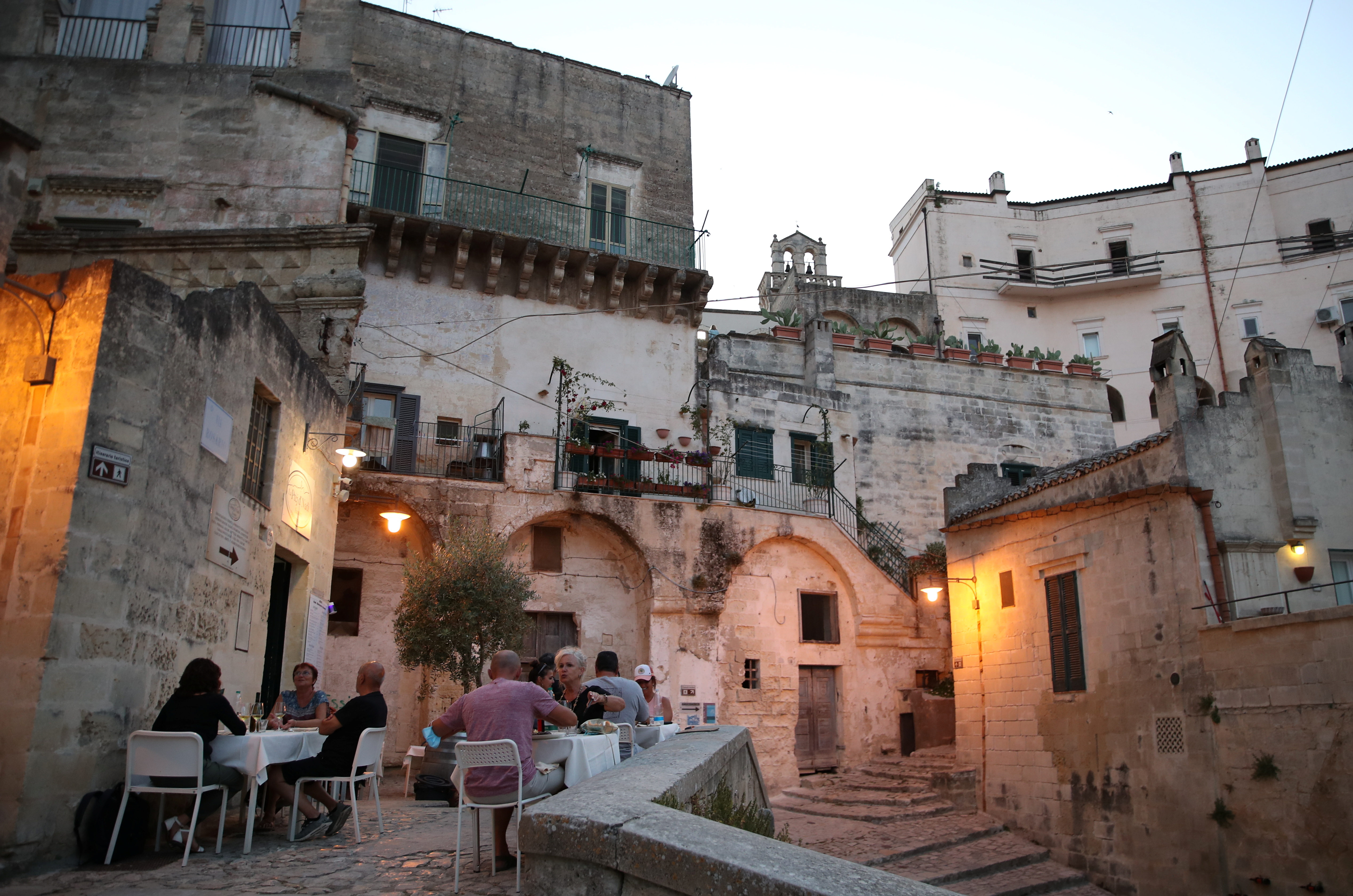 People enjoy the evening at a restaurant in Matera, Italy