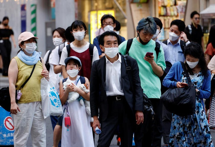 People wearing protective masks amid the coronavirus disease (COVID-19) outbreak, stand in front of cross walk in Tokyo