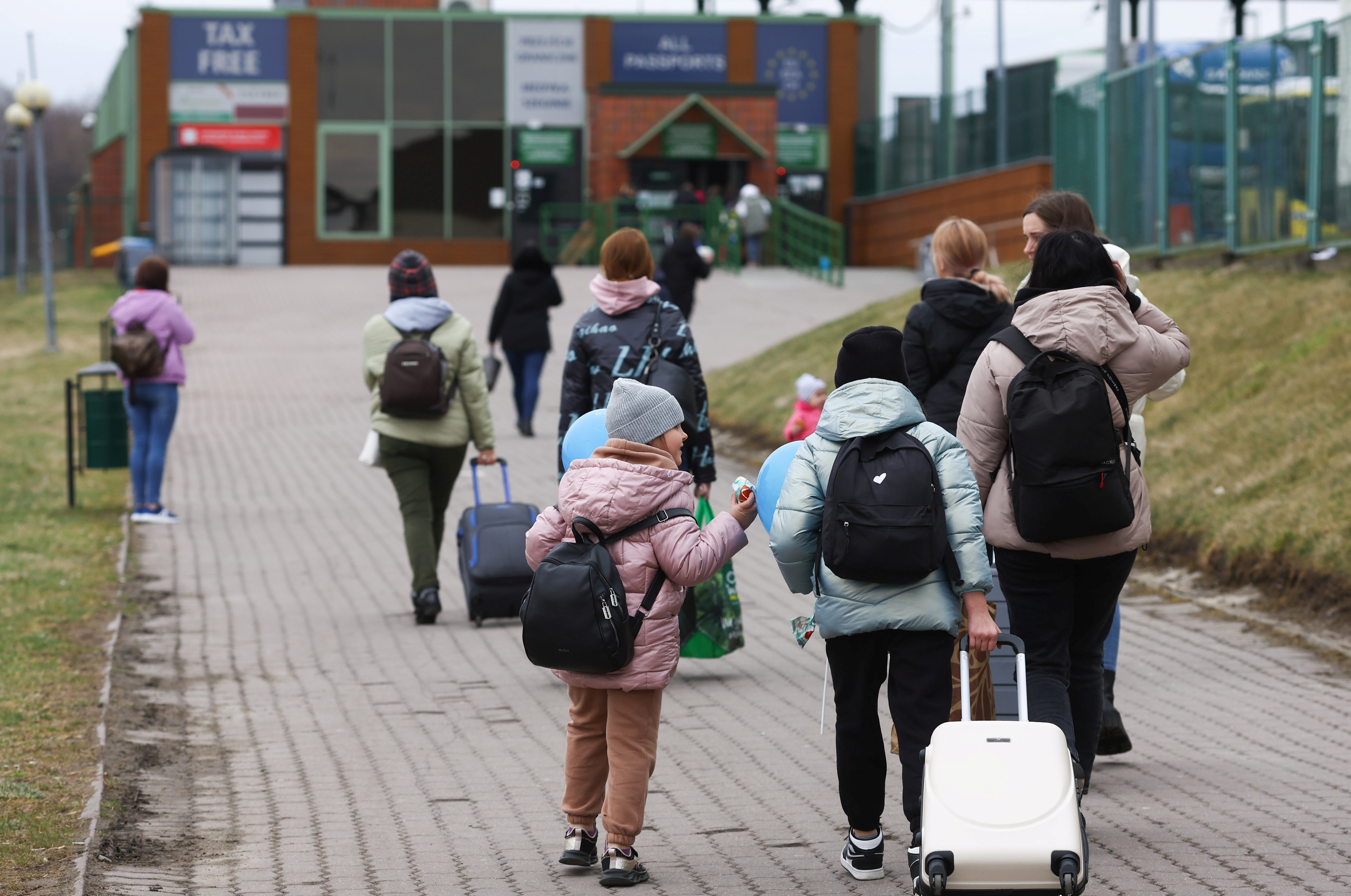 Ukrainian refugees walk towards border crossing from Poland to Ukraine, amid the Russian invasion of Ukraine, in Medyka