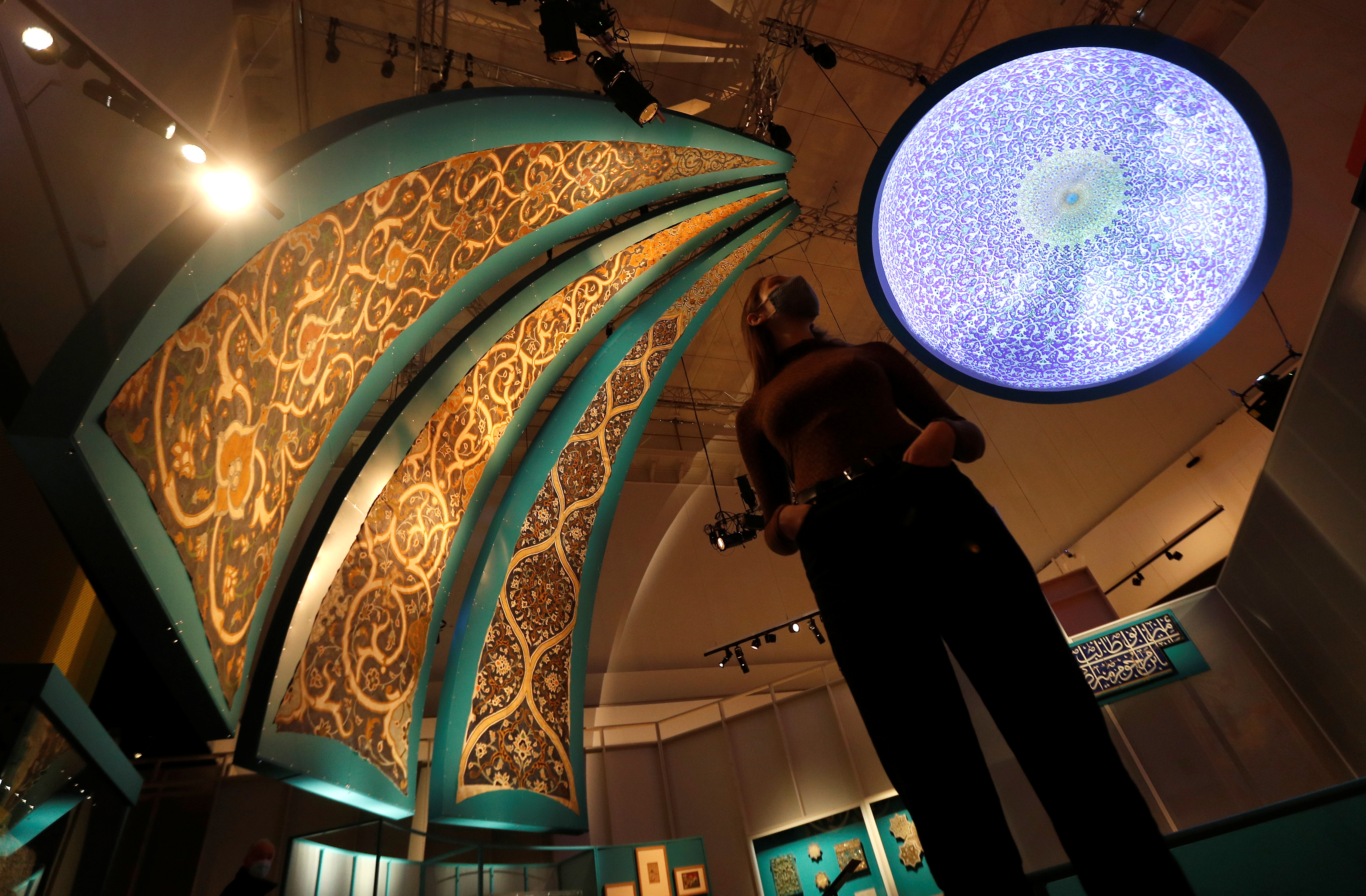 A V&A employee looks up at the Dome Projection and triangular paintings recreating tiled interiors of mosque domes in Isfahan which are on display at Epic Iran, an exhibition soon to open at the V&A in London, Britain, May 25, 2021. REUTERS/Peter Nicholls
